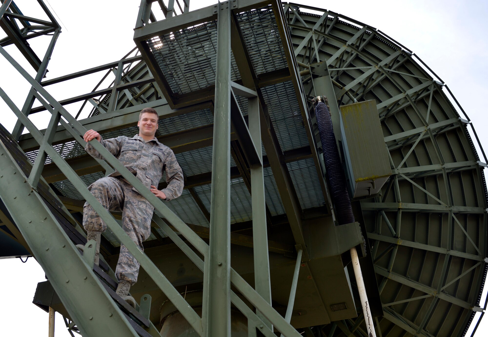 Senior Airman Ryan Pastor, 460th Space Communications Squadron radio frequency transmissions system journeyman, stands beside a radio dish May 4, 2015, at Ramstein Air Base, Germany. Pastor says he will miss being able to work hands-on with dishes and more as he leaves his enlisted life to commission as an Air Force officer via the Leaders Encouraging Airman Development program. (U.S. Air Force photo by Airman 1st Class Lane T. Plummer/Released)
