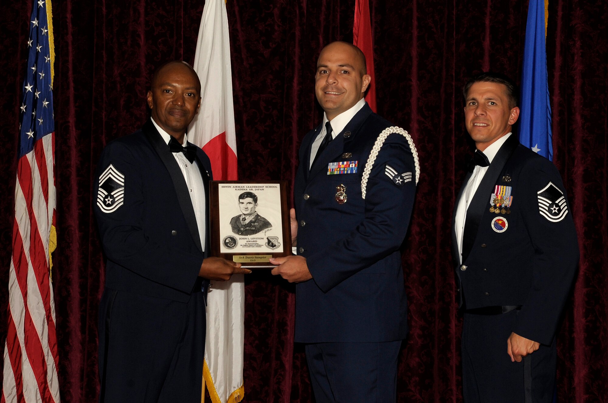 U.S. Air Force Senior Airman Travis Sumpter, 18th Security Forces squadron, accepts the John L. Levitow Award during the graduation ceremony for ALS Class 15-D on Kadena Air Base, Japan, May 5, 2015. The John L. Levitow Award is presented to the student who earns the highest average score on evaluations and most embodies the Ar Force core values. (U.S. Air Force photo by Airman 1st Class Zackary A. Henry/Released)