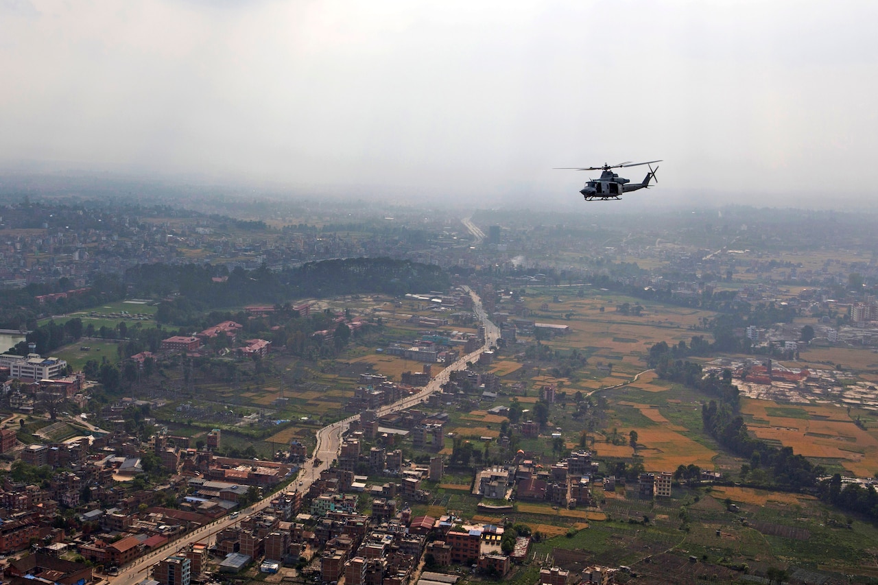 A U.S. Marine Corps UH-1Y Huey helicopter flies over a valley en route to deliver aid and relief supplies to remote areas of the Dolakha and Sindhuli districts in Nepal May, 10, 2015, during Operation Sahayogi Haat, which means "helping hand" in Nepali. U.S. Marine Corps photo by Staff Sgt. Jeffrey D. Anderson