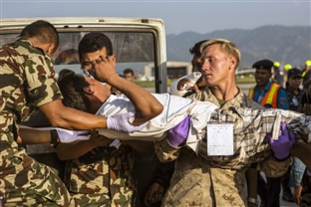 U.S. Marine Corps Cpl. Aaron Nicholsan helps an earthquake victim into an ambulance at a medical triage area at Tribhuvan International Airport in Nepal, May 12, 2015, after a magnitude-7.3 earthquake aftershock. Joint Task Force 505 and other multinational forces and humanitarian relief organizations deployed to Nepal to provide aid after the first earthquake struck April 25. 