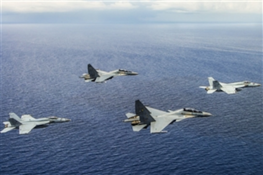 Two U.S. Navy F/A-18 Super Hornets and two Malaysian air force Su-30MKI Flanker-H aircraft fly in formation during an exercise over the South China Sea, May 10, 2015. The exercise promotes cooperation between the U.S. Navy and Malaysian military. The F/A-18 Super Hornets are deployed with the Carl Vinson Carrier Strike Group.