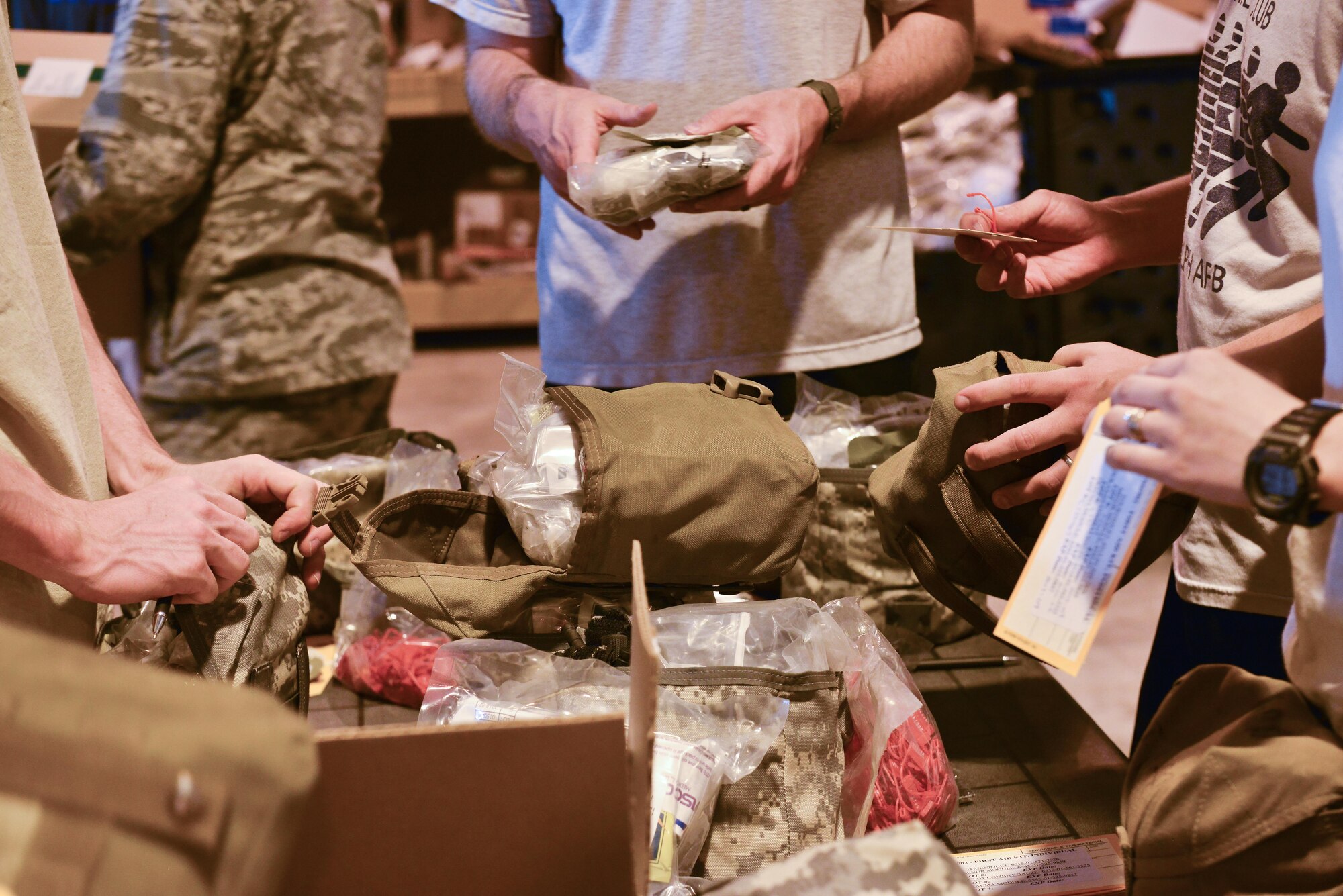 Service members deployed to the Al Udeid Air Base unpack and sort Improved First-Aid Kits (IFAK) that will be re-packaged and certified during a volunteer event held by the 379th Medical Logistics Squadron May 8, 2015 at Al Udeid Air Base, Qatar. IFAKS help increase deployed members’ capabilities to perform Self-aid and or Buddy-aid care to intervene in the event of battlefield casualty or injuries. (U.S. Air Force photo by Staff Sgt. Alexandre Montes)  