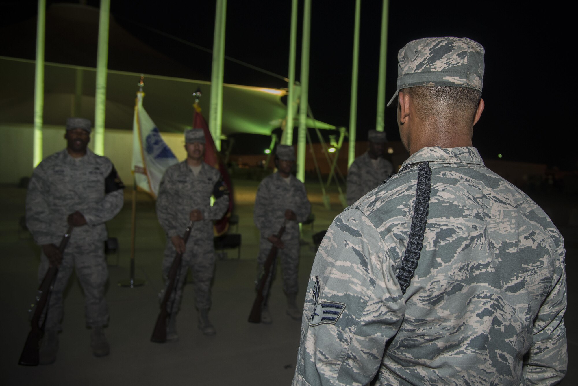 Senior Airman Keith Washington, honor guard instructor, 379th Expeditionary Logistics Squadron, looks on while honor guard members train on the proper use of ceremonial rifles during training May 11, 2015, at Memorial Plaza on Al Udeid Air Base, Qatar. Washington is one of seven instructors responsible for training the base honor guard in preparation to perform their details for wing events. (U.S. Air Force photo by Tech. Sgt. Douglas)