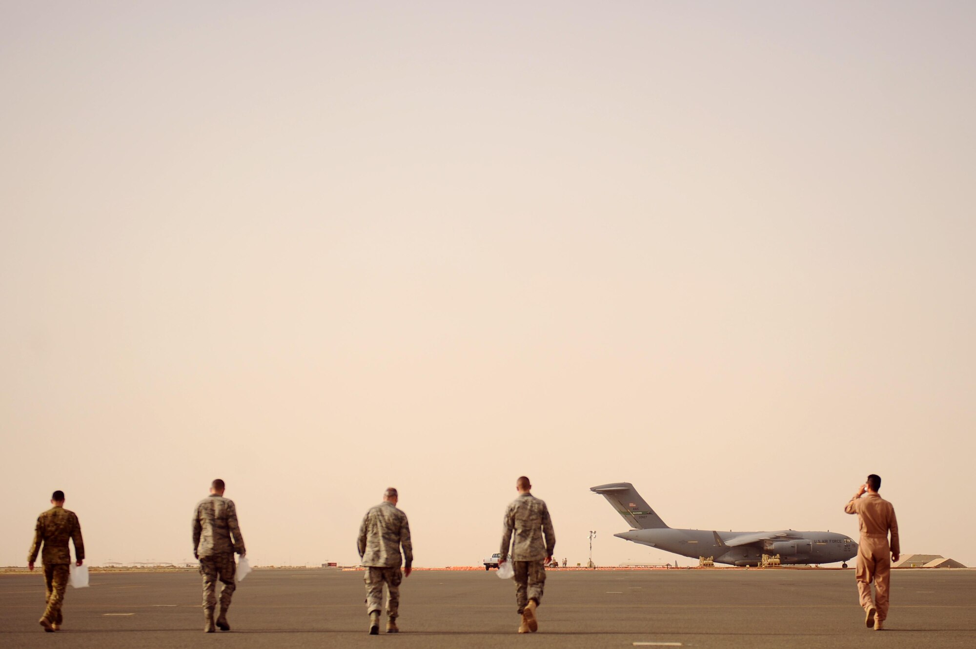 U.S. Airmen of the 386th Air Expeditionary Wing pick up trash on the flightline during a Foreign Object Debris Walk or “FOD Walk” at an undisclosed location in Southwest Asia, May 15, 2015. Airmen routinely clean the flightline to prevent aircraft from ingesting foreign debris that can cause engine or structural damage. (U.S. Air Force photo/Tech. Sgt. Brittany E. Jones)