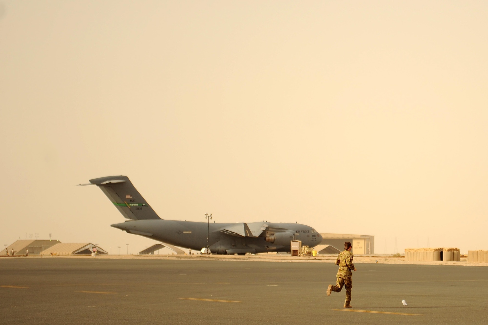 U.S. Air Force Capt. Thomas Hixon, 46th Expeditionary Reconnaissance Squadron, chases a piece of trash down the flightline during a routine Foreign Object Debris Walk or “FOD Walk” at an undisclosed location in Southwest Asia, May 15, 2015. “FOD” is any substance, debris or article foreign to an aircraft system which could potentially cause damage. (U.S. Air Force photo/Tech. Sgt. Brittany E. Jones)