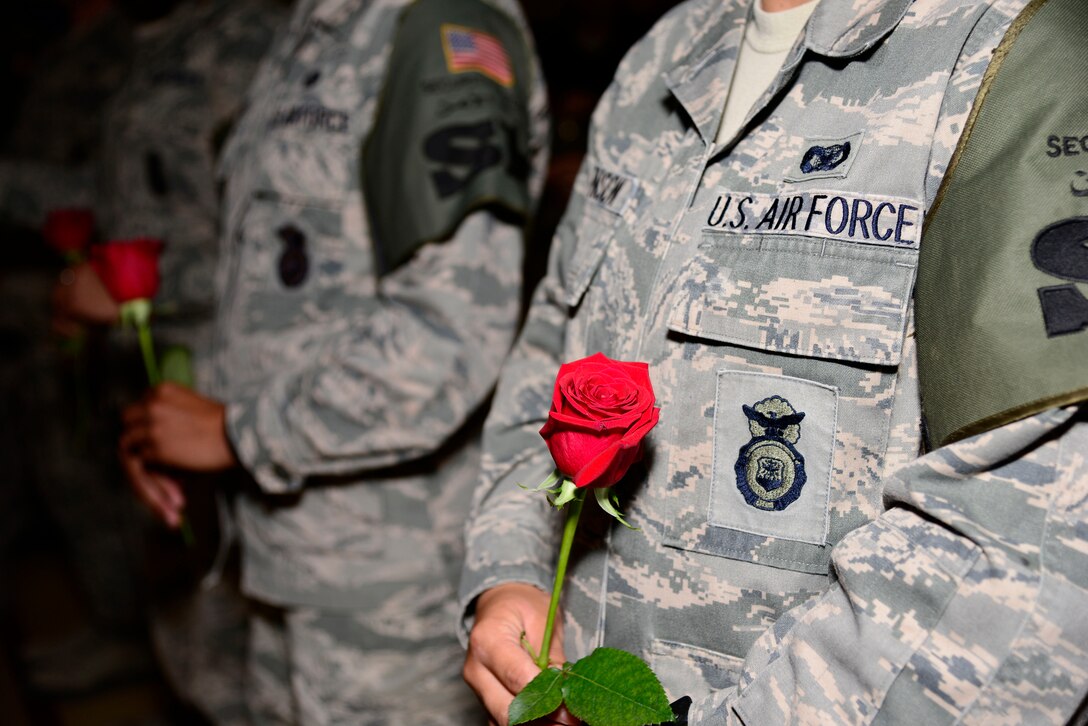 Members of the 386th Expeditionary Security Forces Squadron hold roses for their fallen comrades during a National Police Week memorial ceremony at an undisclosed location in Southwest Asia May 14, 2015. National Police Week, which occurs annually, pays special recognition to those law enforcement officers, civilian and military, who lost their lives in the line of duty for the safety and protection of others. (U.S. Air Force photo by Senior Airman Racheal E. Watson/Released)