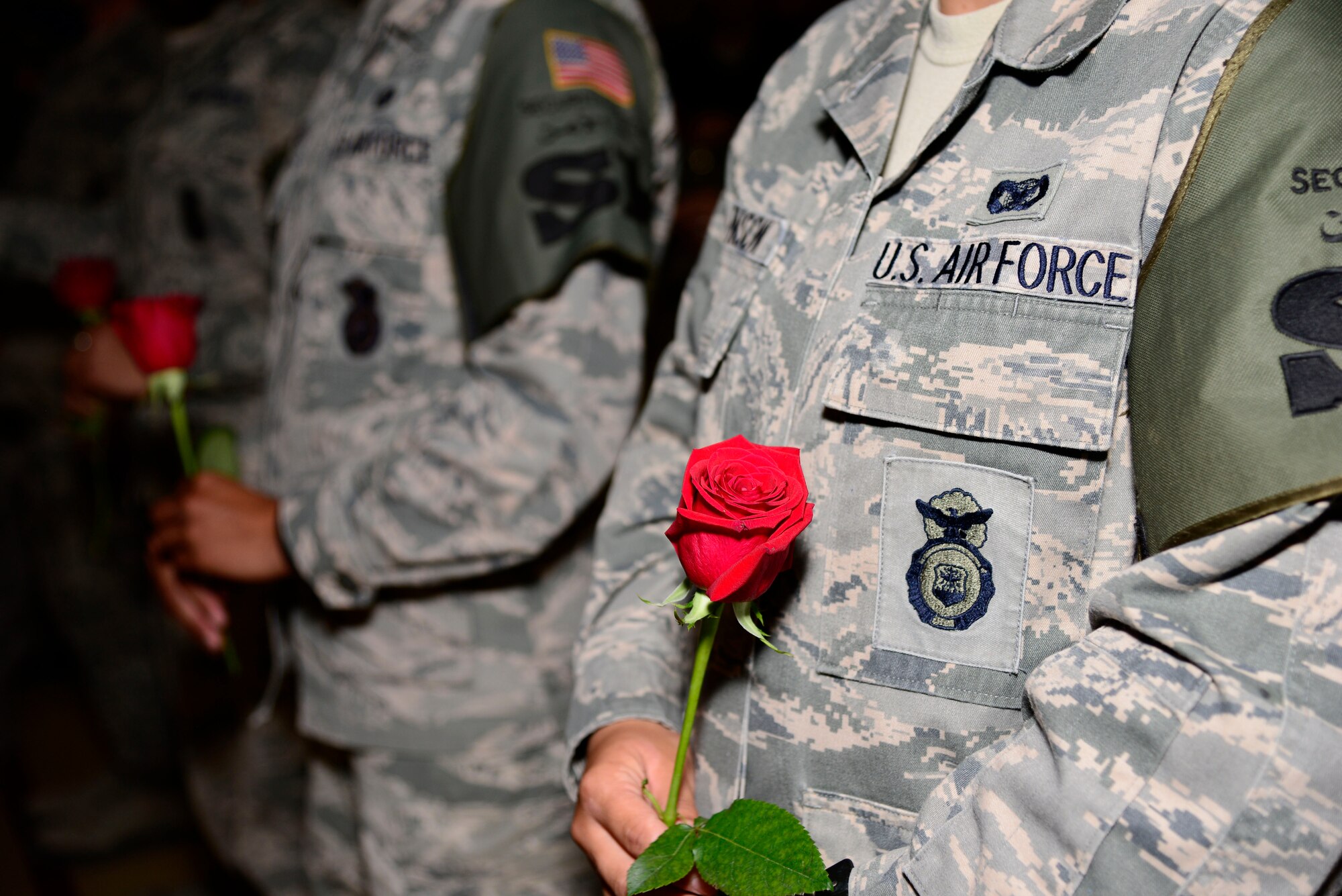 Members of the 386th Expeditionary Security Forces Squadron hold roses for their fallen comrades during a National Police Week memorial ceremony at an undisclosed location in Southwest Asia May 14, 2015. National Police Week, which occurs annually, pays special recognition to those law enforcement officers, civilian and military, who lost their lives in the line of duty for the safety and protection of others. (U.S. Air Force photo by Senior Airman Racheal E. Watson/Released)
