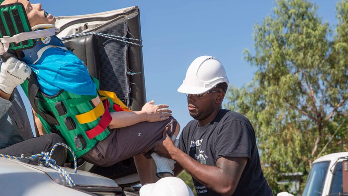 Hospitalman Dante Johnson, a hospital corpsman with Headquarters and Support Company, 1st Battalion, 4th Marine Regiment, Marine Rotational Force – Darwin and a native of Chicago, Illinois, removes an adult patient from an overturned car during a Remote Pre-Hospital Trauma and Disaster Course May 13 at the Marrara Fire Department, Northern Territory, Australia. The course refreshed the corpsmen’s basic casualty care response skills and provided them with lectures, skills labs and real world practical application addressing mass casualty care in remote areas. The MRF-D deployment enables Marines and sailors to effectively train, exercise and operate with partner to enhance regional security and build the capacity to respond more rapidly to natural disasters and crises throughout the region (U.S. Marine Corps photo by Cpl. Reba James/Released)