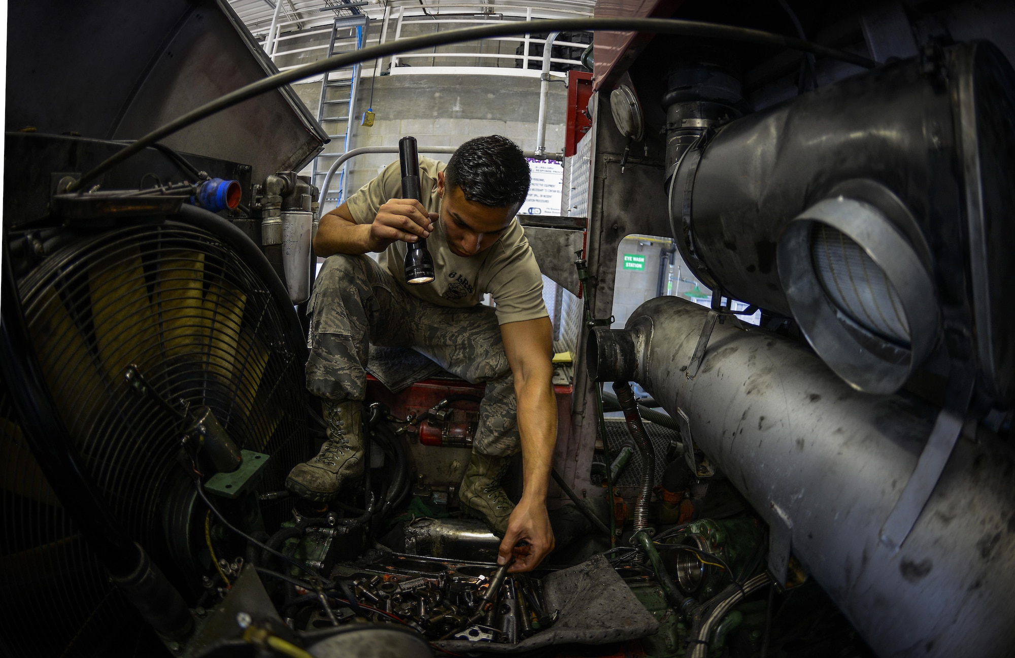 Senior Airman William Concepcion, a 6th Logistics Readiness Squadron fire truck mechanic, picks up an engine part from an airport rescue firefighting truck, May 7, 2015, at MacDill Air Force Base, Fla. The fire truck maintenance shop is responsible for maintaining 10 firefighting trucks. (U.S. Air Force photo/Senior Airman Melanie Bulow-Gonterman)