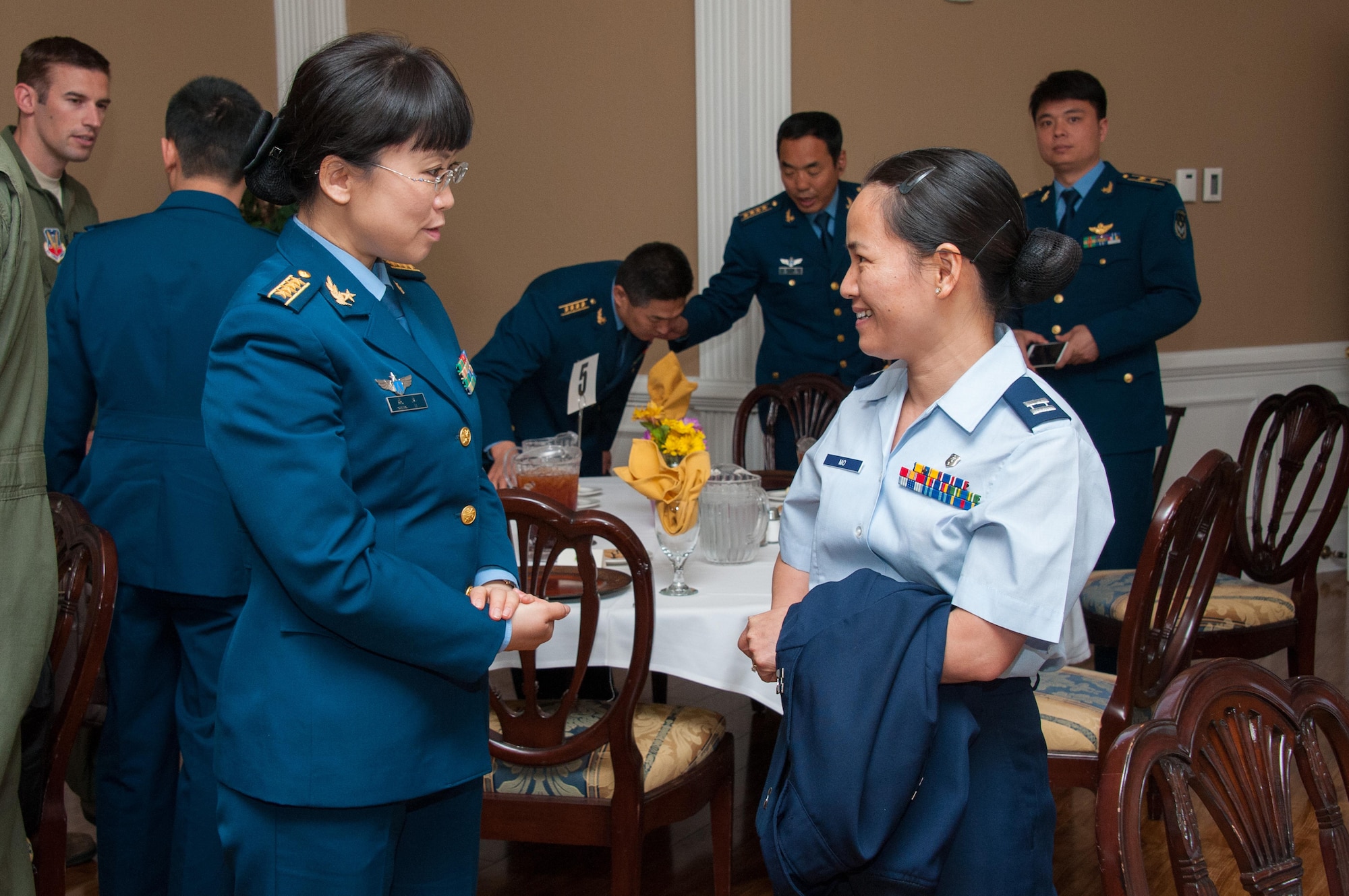 Capt. Shaoping Mo, right, a participant of the Language Enabled Airman Program, right, speaks with a member of the visiting Chinese delegation.  Maj. Gen. Han Xing, deputy commandant of the People's Liberation Army Air Force Command College, along with PLAAF Command College instructors and students, visited Air University headquarters and various AU schools, April 29, 2015. (U.S. Air Force photo by Melanie Rodgers Cox)