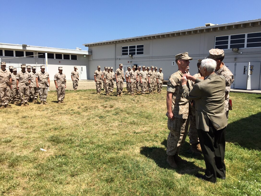 Marine Veteran, Bill Darling pins Lance Cpl. Shane Johnson during a promotion ceremony. During his visit, Darling not only saw the planning, training and execution of the units’ exercise, but he also talked to the Marines, shared stories about his period of service and compared experiences between his time and what the Marines go through today. (Photo courtesy of 4th Force Reconnaissance Company)