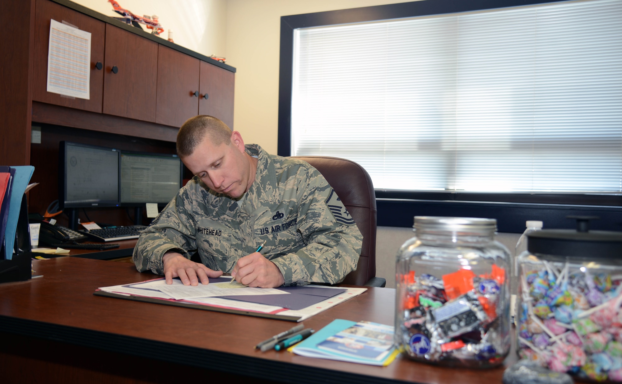 Master Sgt. Jason Whitehead, the 341st Security Forces Squadron first sergeant, completes paperwork in his office May 5, 2015, at Malmstrom Air Force Base, Mont. His duties are split between administrative work and being actively involved in Airmen’s lives. (U.S. Air Force photo/Airman 1st Class Dillon Johnston)