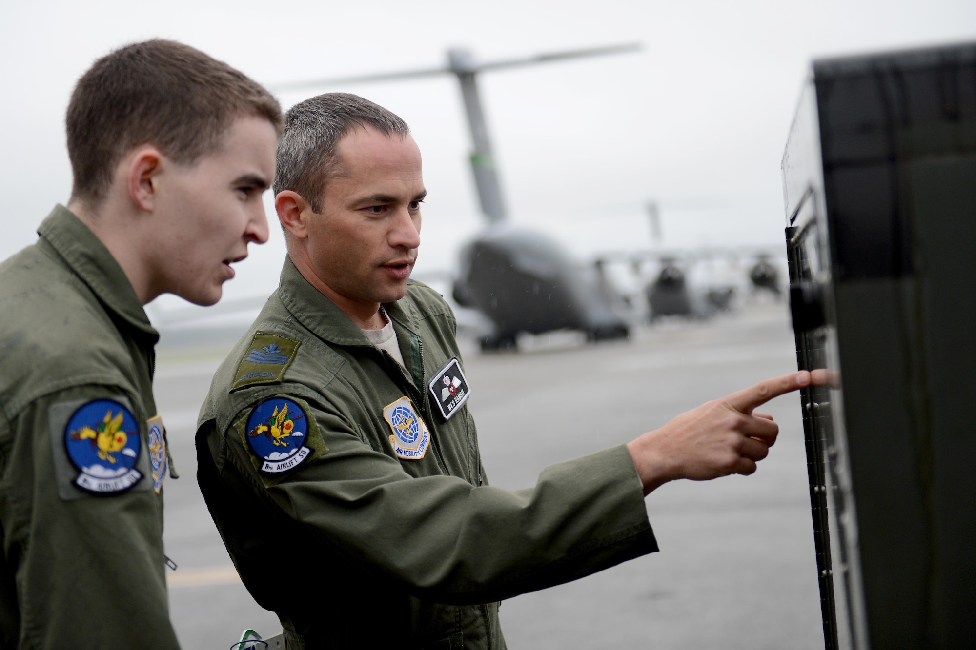 Royal Canadian Air Force Sgt. Wes Ramsay (right), and U.S. Air Force Airman 1st Class Travis Hoose, both 8th Airlift Squadron loadmasters, inspect a generator May 12, 2015, at Joint Base Lewis-McChord, Wash. Ramsay is a part of the military exchange program and works as a loadmaster instructor with the 8th AS. (U.S. Air Force photo/Airman 1st Class Keoni Chavarria)