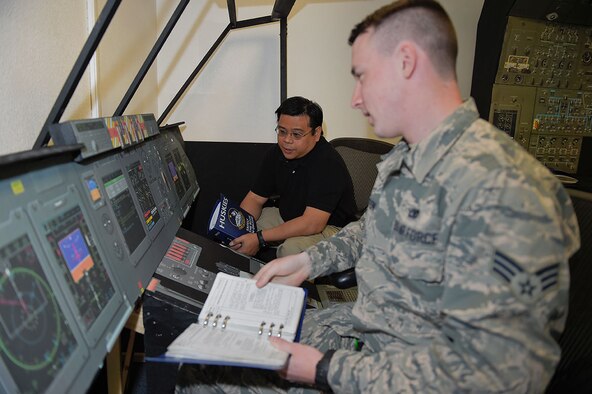 Jolly Tangog, an equipment specialist with Air Force engineering and technical services for the 732nd Air Mobility Squadron, supervises Senior Airman Adam Orton, a jets lead technician, as he uses a C-5M Super Galaxy maintenance trainer on Joint Base Elmendorf-Richardson, Alaska, May 7, 2015. Tangog came up with the cost-saving idea to build a trainer at Elmendorf rather than sending Airmen away on a temporary duty for expensive refresher training. (U.S. Air Force photo/Alejandro Pena)