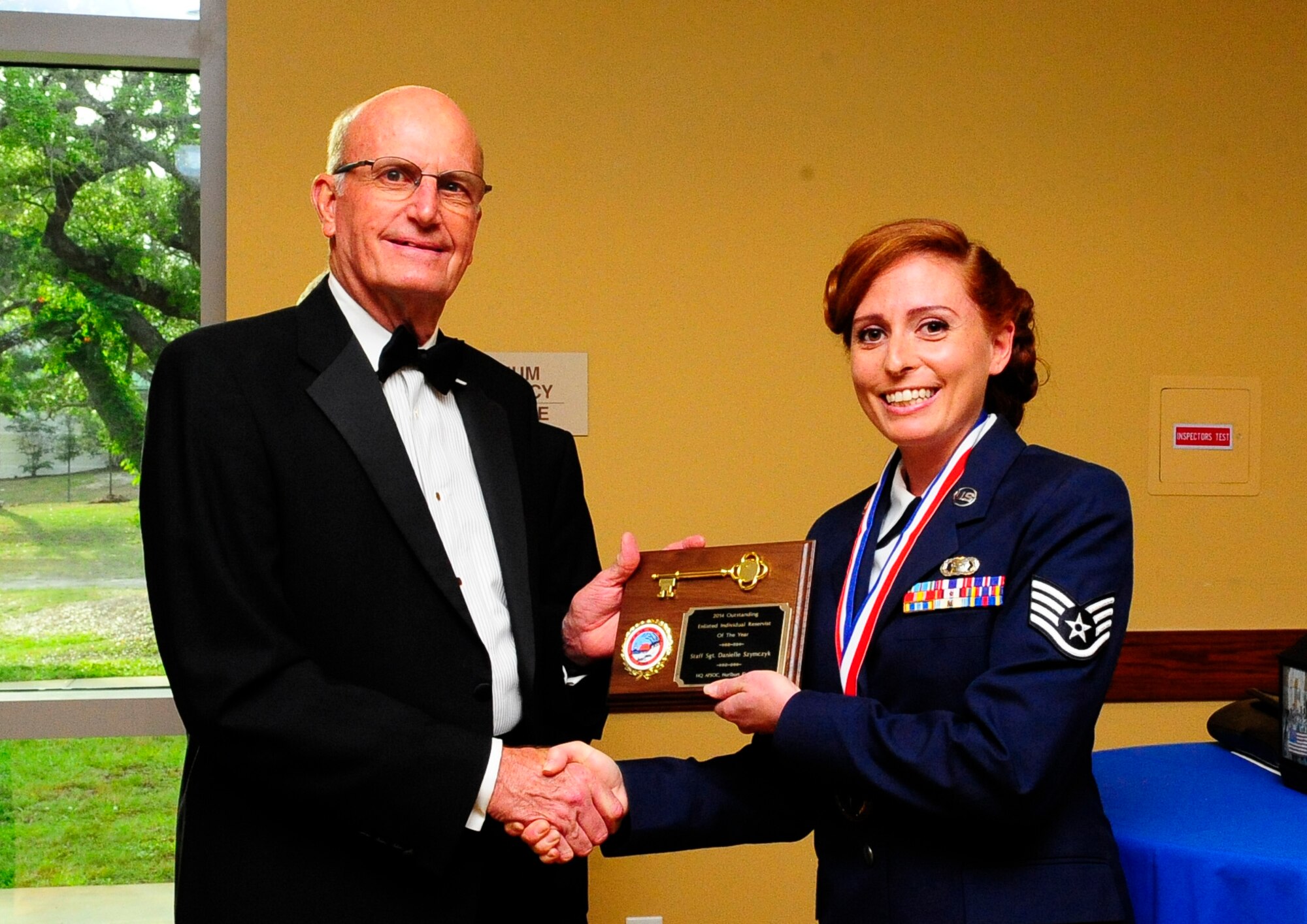 Mayor Mike Anderson, Mayor of Ft Walton Beach, presents a key to the city to Staff Sgt. Danielle Szymcyk, Air Force Special Operations Command's individual reservist of the year (enlisted), during a medallion ceremony held prior to the banquet May 14.  More than 340 Air Commandos celebrated the 2014 Outstanding Airmen and Civilians of the year and honored 25 years of command heritage at the Hurlburt Field Soundside Club.