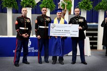 Capt. Joeseph Rieser presents the Naval Reserve Officer Training Corps Scholarship to Thomas Glission at an awards ceremony at Notre Dame Regional High School, Cape Girardeau, MO May 15. Glission will attend The University of Missouri in the fall to being his journey to become a Marine Corps Officer. "What impressed me most about Mr. Glisson is what I perceived to be his commitment to a cause greater than his own," said Rieser, the Executive officer of Recruiting Station St. Louis. "During our interview, I asked him what made him different from the other applicants and what made him unique; he responded 'I am determined to become the best leader I can be.'"