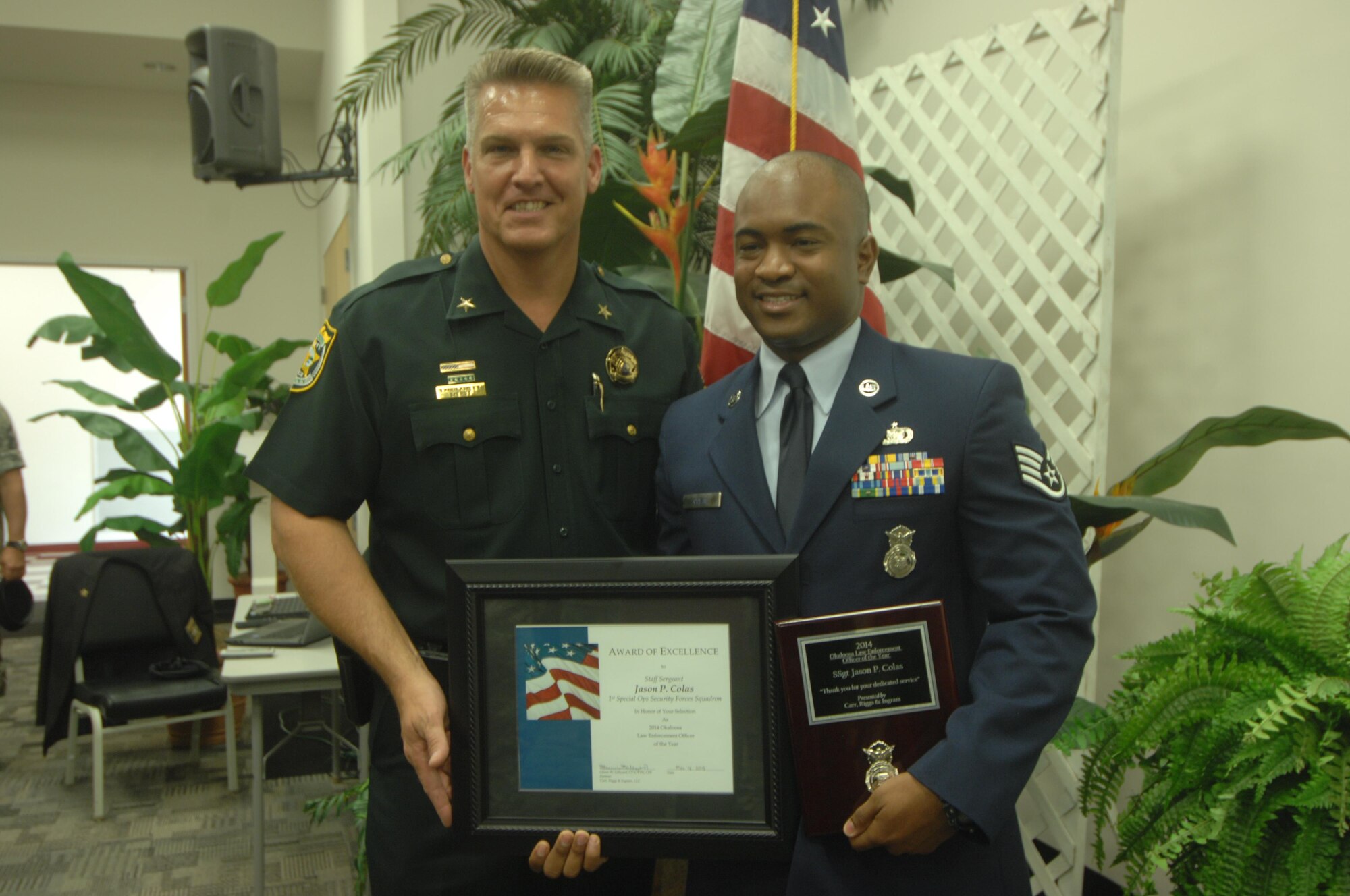 A local law enforcement officer poses with Staff Sgt.Jason Colas, 1st Special Operations Security Forces Squadron security forces ground intelligence NCO in-charge,after Colas was named  the 2014 Okaloosa County Law Enforcement Officer of the Year during the Okaloosa County Law Enforcement Appreciation Lunch, May 12, 2015. (Photo courtesy of Northwest Florida Daily News)