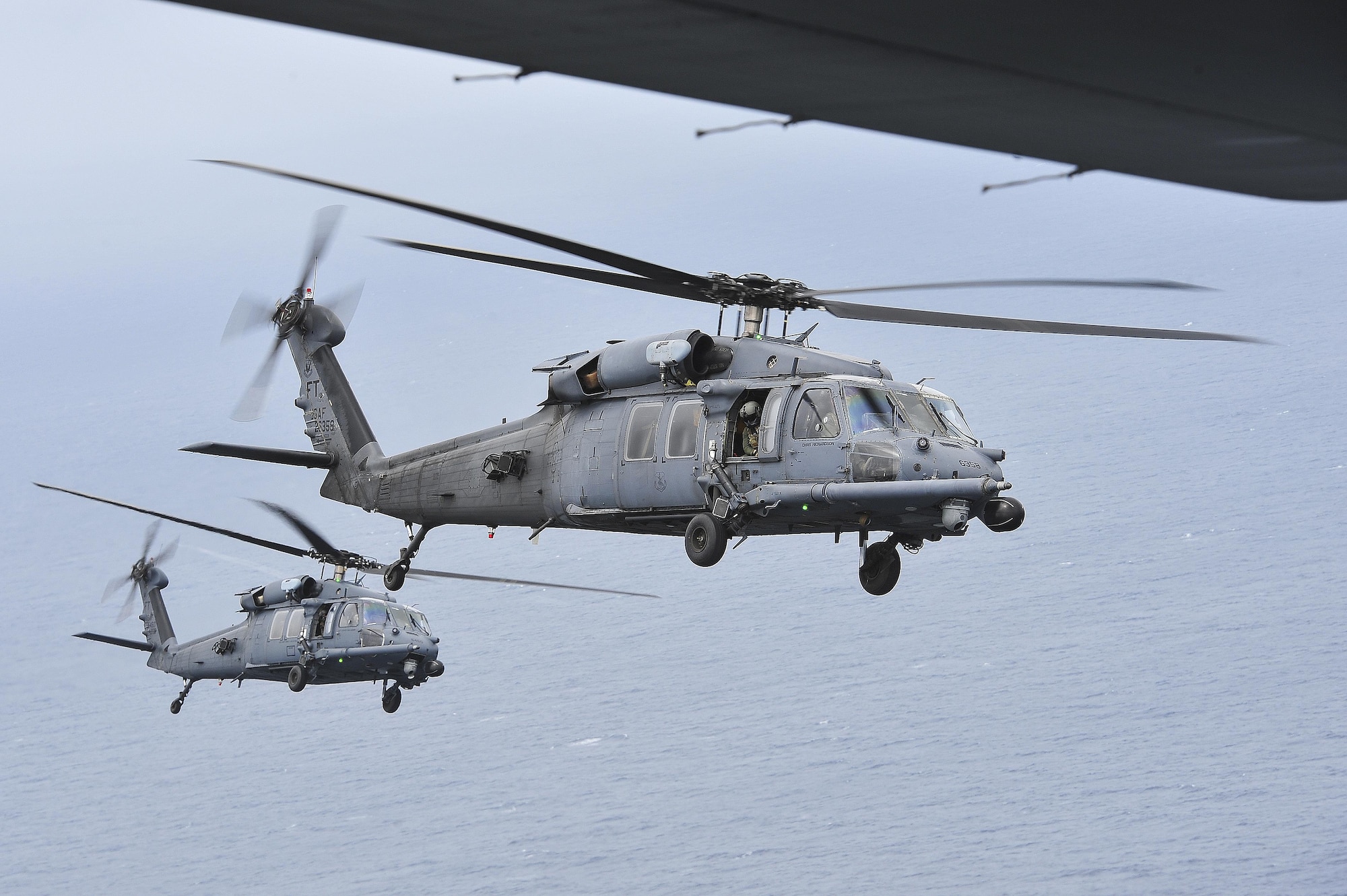 Two HH-60G Pave Hawk helicopters from the 41st Rescue Squadron, Moody Air Force Base, Ga., fly in formation in preparation for an air-to-air refueling with an MC-130P Combat Shadow over Hurlburt Field, Fla., May 15, 2015. The final two MC-130P Combat Shadow aircraft in the Air Force landed for the last time at Hurlburt Field, Fla., in front of more than 400 people and will take their last flight to the boneyard at Davis-Monthan Air Force Base, Arizona, June 1. (U.S. Air Force photo/Senior Airman Jeff Parkinson)