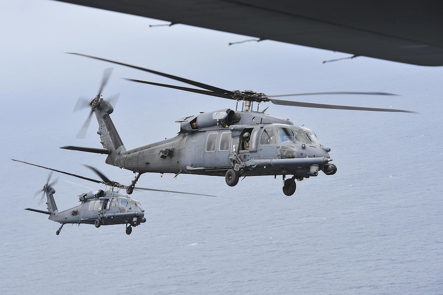 Two HH-60G Pave Hawk helicopters from the 41st Rescue Squadron, Moody Air Force Base, Ga., fly in formation in preparation for an air-to-air refueling with an MC-130P Combat Shadow over Hurlburt Field, Fla., May 15, 2015. The final two MC-130P Combat Shadow aircraft in the Air Force landed for the last time at Hurlburt Field, Fla., in front of more than 400 people and will take their last flight to the boneyard at Davis-Monthan Air Force Base, Arizona, June 1. (U.S. Air Force photo/Senior Airman Jeff Parkinson)