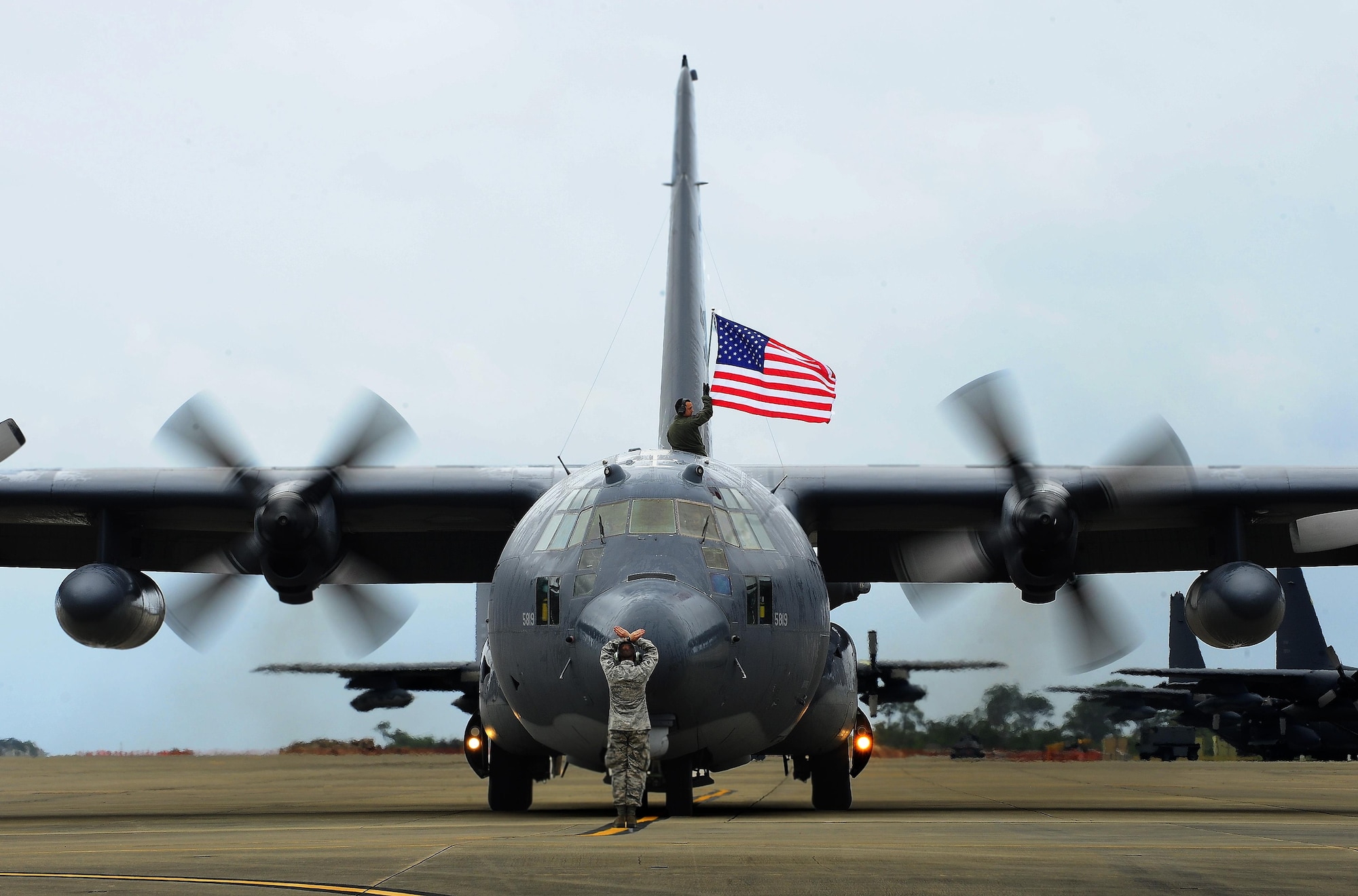 Tech. Sgt. Bruce Ramos, 1st Special Operations Group Detachment 1 radio operator, raises the American flag after retiring the MC 130 P Combat Shadow at Hurlburt Field Fla., May 15, 2015. Built with 1960s technology, the MC-130P began its special operations career in the mid-1980s and went on to conduct critical air refueling missions in the late 1980s during Operation Just Cause in Panama and the early 1990s during Operation Desert Storm. (U.S. Air Force photo/Airman 1st Class Andrea Posey)