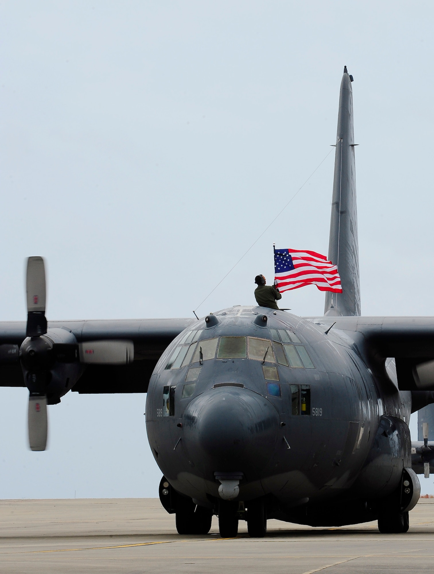 Tech. Sgt. Bruce Ramos, 1st Special Operations Group Detachment 1 radio operator, raises the American flag after retiring the MC 130 P Combat Shadow at Hurlburt Field Fla., May 15, 2015. Built with 1960s technology, the MC-130P began its special operations career in the mid-1980s and went on to conduct critical air refueling missions in the late 1980s during Operation Just Cause in Panama and the early 1990s during Operation Desert Storm. (U.S. Air Force photo/Airman 1st Class Andrea Posey)