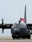 Tech. Sgt. Bruce Ramos, 1st Special Operations Group Detachment 1 radio operator, raises the American flag after retiring the MC 130 P Combat Shadow at Hurlburt Field Fla., May 15, 2015. Built with 1960s technology, the MC-130P began its special operations career in the mid-1980s and went on to conduct critical air refueling missions in the late 1980s during Operation Just Cause in Panama and the early 1990s during Operation Desert Storm. (U.S. Air Force photo/Airman 1st Class Andrea Posey)