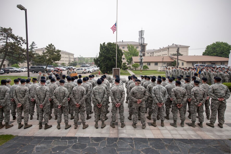 Wolf Pack Airmen stand in formation to honor security forces members who made the ultimate sacrifice in the line of duty during a retreat ceremony May 15, 2015, at Kunsan Air Base, Republic of Korea. Members of the Wolf Pack recognized the importance of crime prevention during National Police Week various observances, including demonstrations by the military work dog section, combat arms and weapons display, crime prevention skits and defender challenge. (U.S. Air Force photo by Senior Airman Katrina Heikkinen/Released)