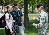 Tech. Sgt. Paul Lamelin, 8th Security Forces Squadron resource protection NCO in charge (right), lauds Master Sgt. Henrietta Pugh, 80th Fighter Squadron superintendent (left), for helping Senior Airman Taylor Curry, 8th Fighter Wing Public Affairs photojournalist (center), who was simulating the effects of irresponsible alcohol consumption during National Police Week May 14, 2015, at Kunsan Air Base, Republic of Korea. In an effort to visibly demonstrate the dangers of excessive alcohol consumption, the Sexual Assault Theater Group teamed up with Lamelin to conduct skits involving Airmen simulating drunk/disorderly conduct to unknowing observers in various public settings during duty hours. (U.S. Air Force photo by Senior Airman Katrina Heikkinen/Released)