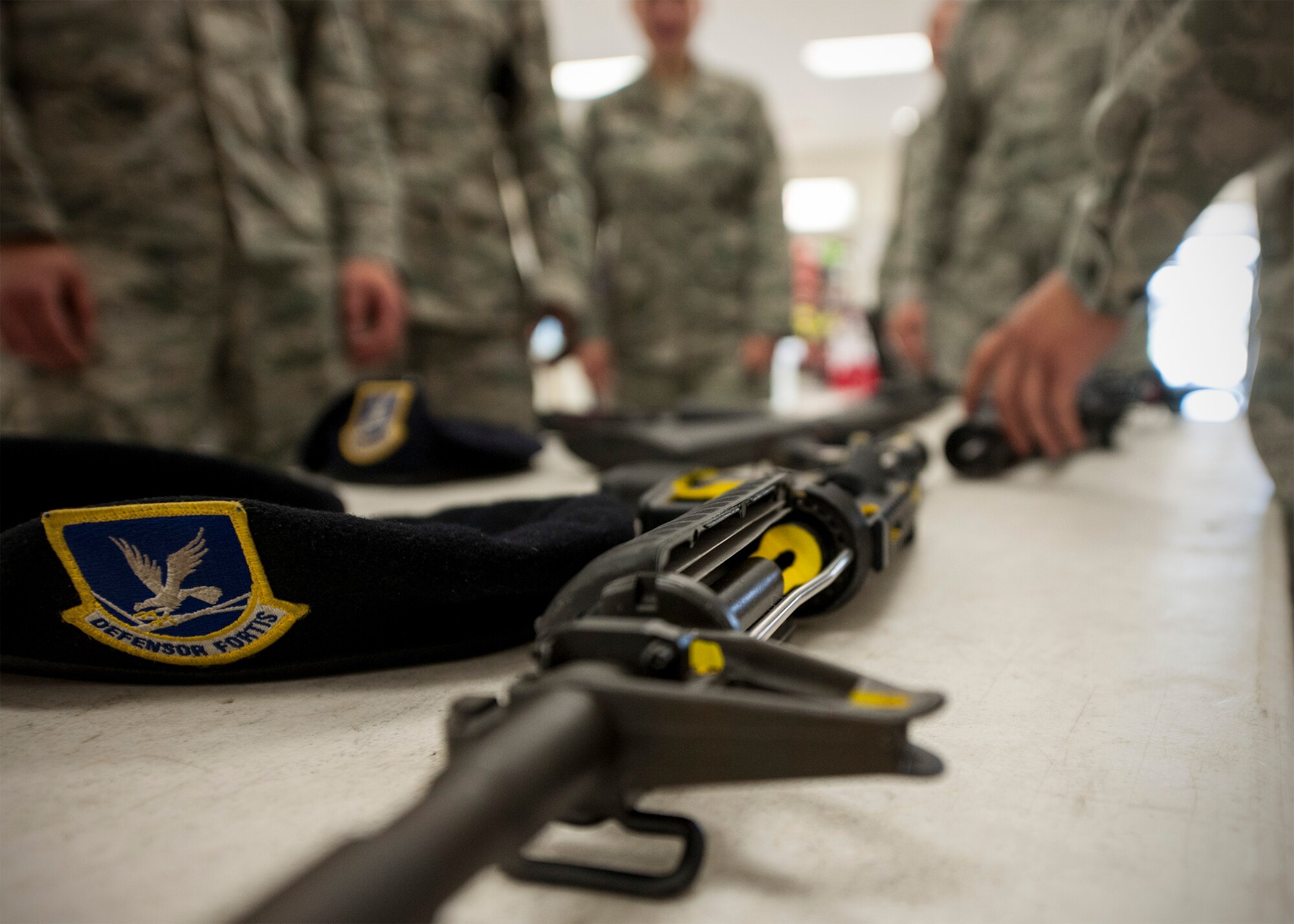 Wolf Pack members huddle around a weapons display May 13, 2015, at the Base Exchange during National Police Week observances at Kunsan Air Base, Republic of Korea. This year’s observance of police week recognized the Wolf Pack’s defenders varied skillsets by highlighting their role in protecting the people, property and resources of the U.S. Air Force, by including demonstrations by the military work dog section, combat arms and weapons display, crime prevention skits, defender challenge and a retreat ceremony. (U.S. Air Force photo by Senior Airman Katrina Heikkinen/Released)