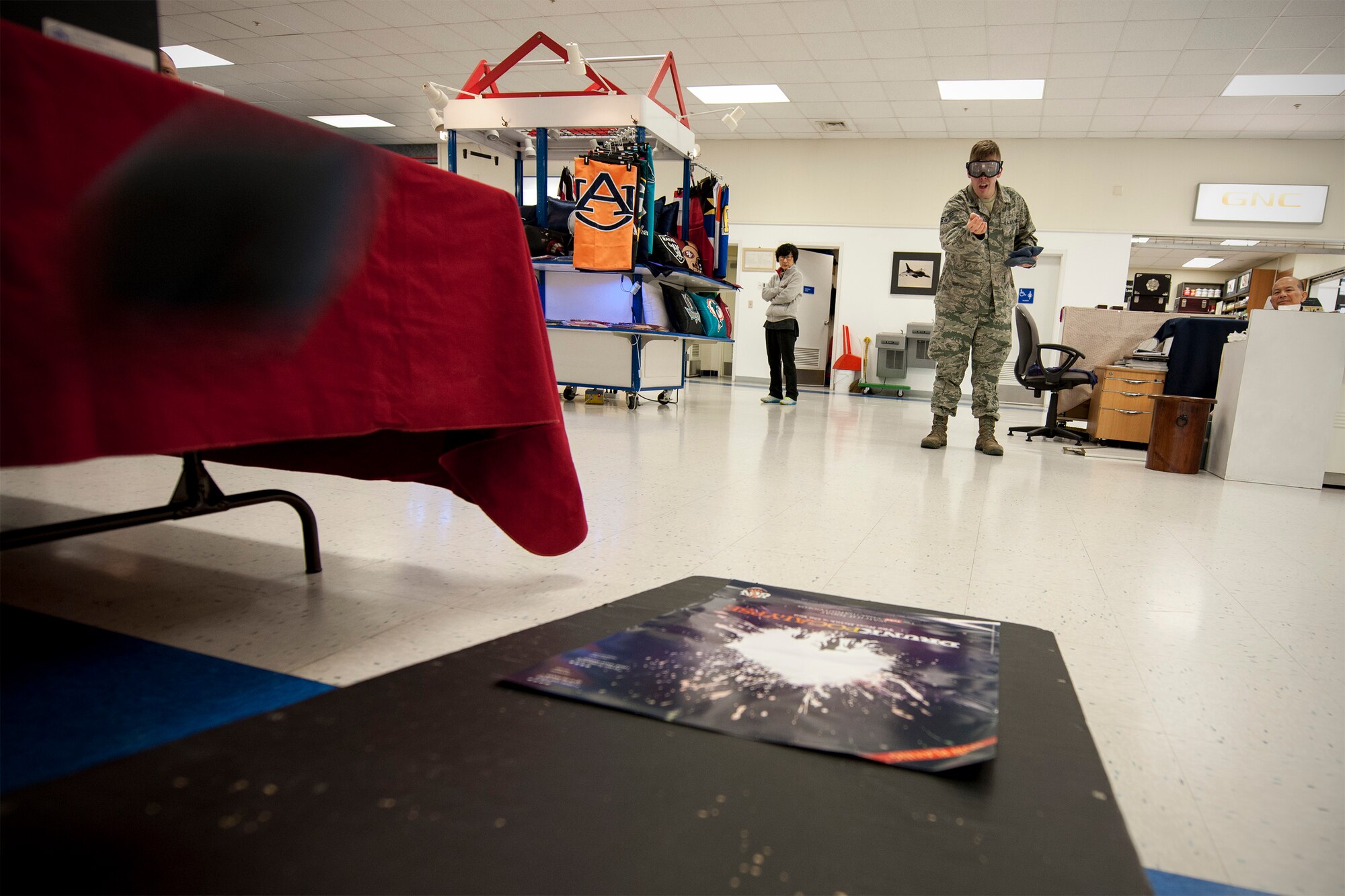 Senior Airman Taylor Curry, 8th Fighter Wing Public Affairs photojournalist, throws a beanbag during a game of corn hole wearing simulated drunk goggles that demonstrate the effects of excessive alcohol consumption during National Police Week May 12, 2015, at Kunsan Air Base, Republic of Korea. Members of the Wolf Pack recognized the importance of crime prevention during National Police Week observances May 11 to 15. (U.S. Air Force photo by Senior Airman Katrina Heikkinen)
