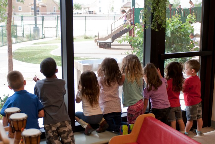 Children look out the window to watch the kids on the playground at the Child Development Center on Nellis Air Force Base, Nev., May 13, 2015. The learning curriculum at the CDCs is based on a child’s individual needs and interests. (U.S. Air Force photo by Airman 1st Class Mikaley Towle)