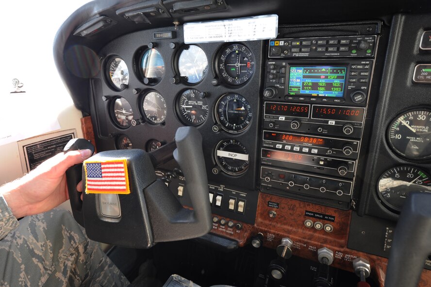 An American flag sticks to the controls of the Cessna II 182 P aircraft, May 14, 2015, over Colville National Forest, Wash. It is tradition, and required, to have an American flag present during re-enlistments. (U.S. Air Force photo/Nicolo J. Daniello)