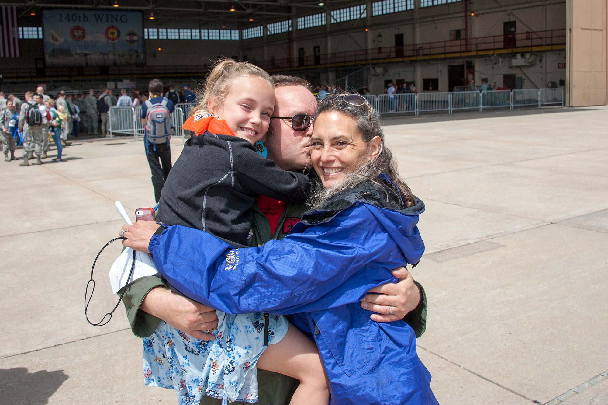 Lt. Col. Craig Wolf, an F-16 pilot with the 120th Fighter Squadron, 140th Wing, embraces his wife and daughter at Buckley AFB, Colo. May 15, 2015 after returning home from a 3-month deployment to the Republic of Korea. (U.S. Air National Guard photo by Senior Master Sgt. John Rohrer) 