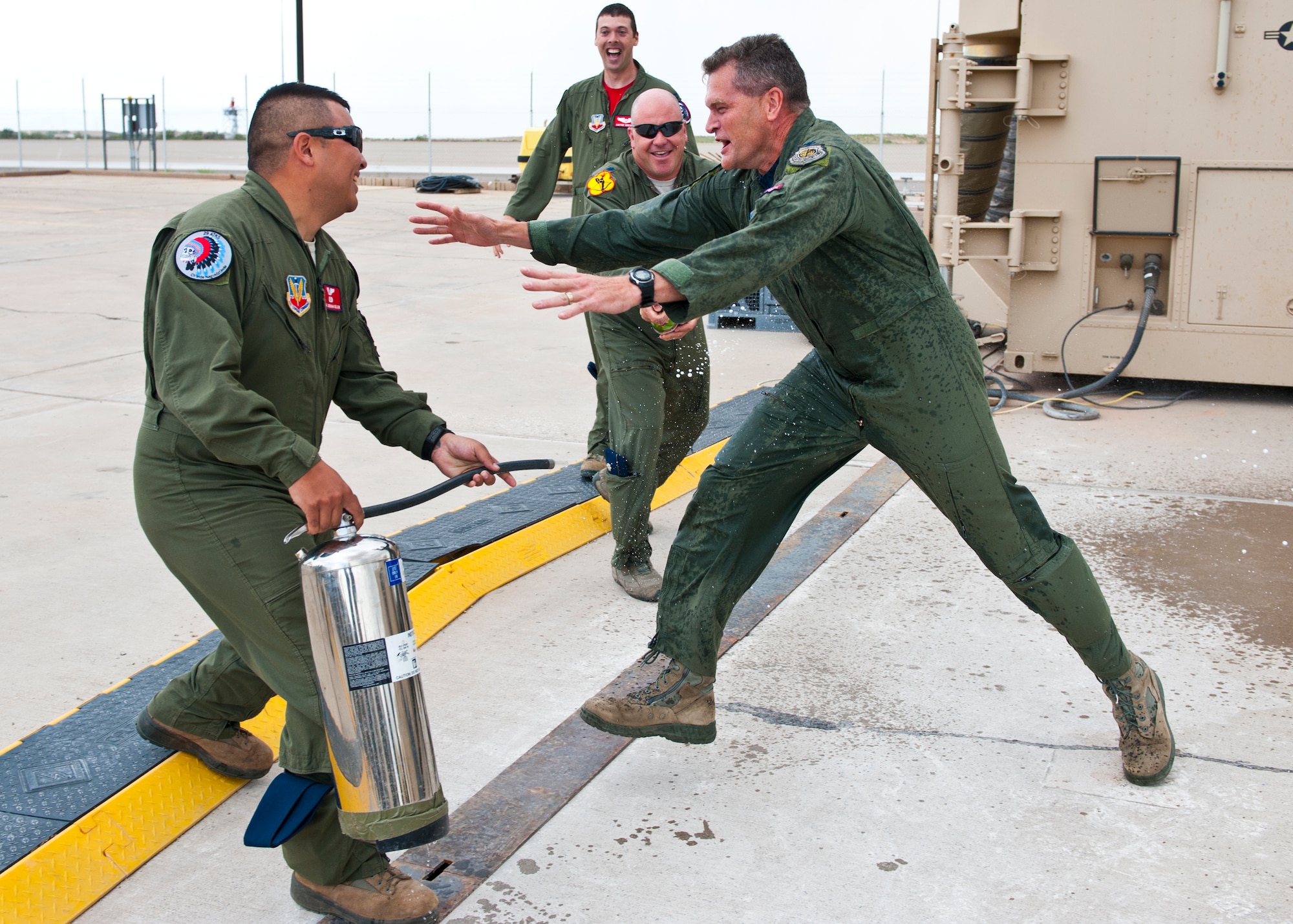 Colonel James Thompson, 49th Wing vice commander tries to avoid the water blast after stepping out of an Remotely Piloted Aircraft, Ground Control Station upon completing his final flight at Holloman Air Force Base, N.M. May 15, 2015. Members of the 29th and 9th Attack Squadrons showered Thompson with water as part of a tradition dating back to World War II. (U.S. Air Force photo by Senior Airman Leah Ferrante/released)