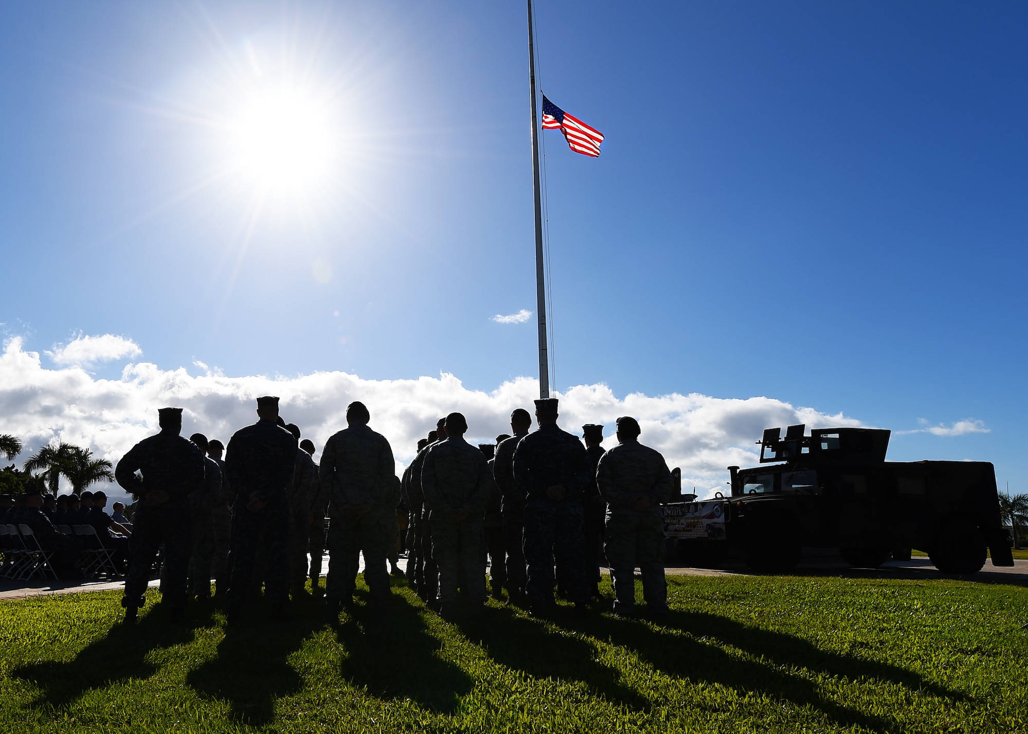 A joint formation of Airmen and Sailors from the Joint Base Security Department  look on as members of the honor guard raise the flag to half-staff in honor of National Peace Officers’ Memorial Day at JBPHH, Hawaii, May 15, 2015. In 1962, President Kennedy declared May 15 as National Peace Officers’ Memorial Day and the calendar week in which May 15 falls as National Police Week. Since then, Police Week has served as a time to pay special recognition to law enforcement officers who lost their lives in the line of duty for the safety and protection of others. (U.S. Air Force photo by Tech. Sgt. Aaron Oelrich/RELEASED)