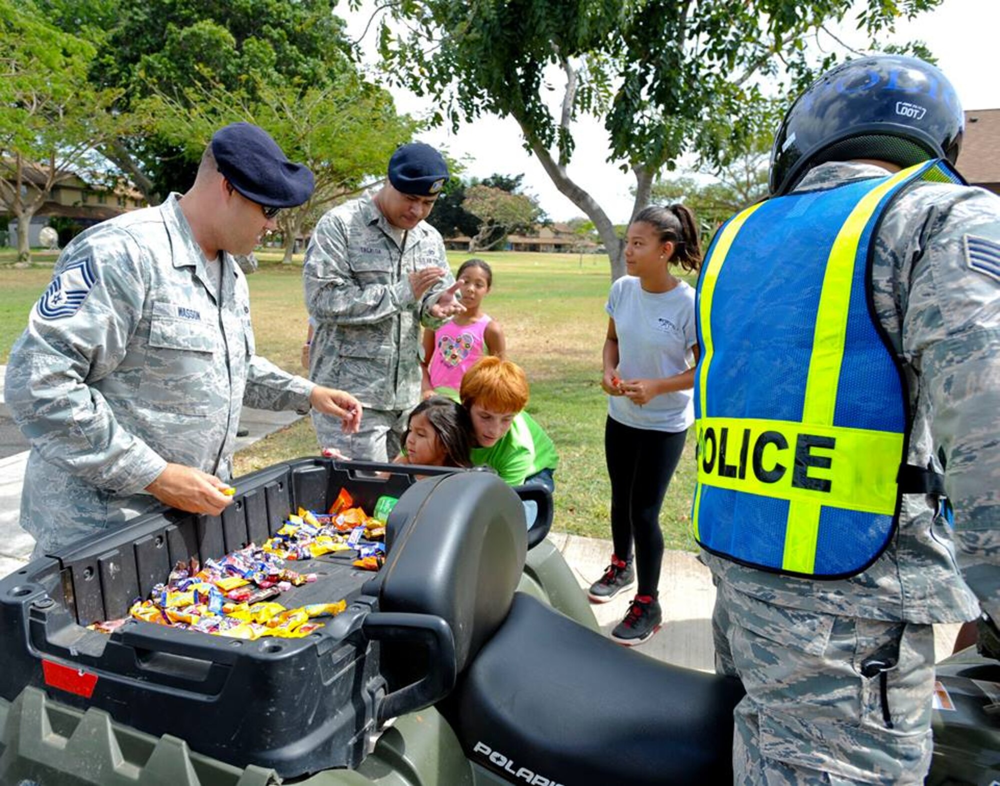 647th Security Forces Squadron Defenders stop to hand out candy during their Police on Patrol Parade through Hickam Communities to kick off Police Week May 11, 2015, at Joint Base Pearl Harbor-Hickam, Hawaii. In 1962 President Kennedy declared May 15 as National Peace Officers’ Memorial Day and the calendar week in which May 15 falls as National Police Week. Since then, Police Week has served as a time to pay special recognition to law enforcement officers who lost their lives in the line of duty for the safety and protection of others. (U.S. Air Force photo by Tech. Sgt. Terri Paden)