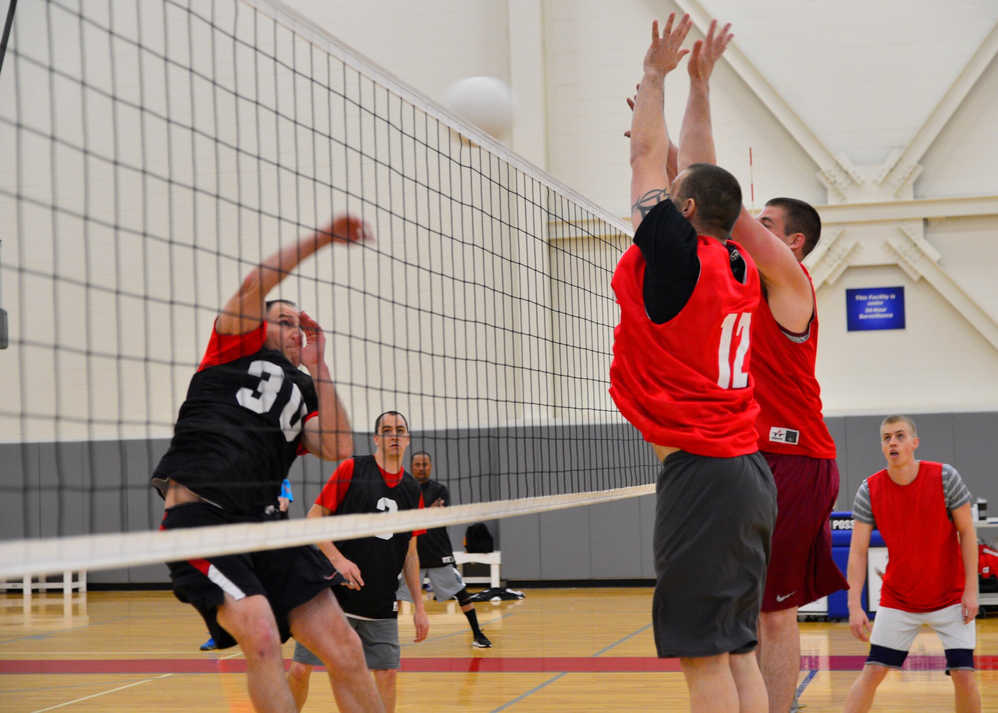 Matthew Husemann, 9th Airlift Squadron, spikes a volleyball while Eric Johnson, front, and Steven Fisher, rear, combined 436th and 736th Aircraft Maintenance Squadrons, attempt to block it during the intramural volleyball championship game May 14, 2015, at the Fitness Center on Dover Air Force Base, Del. The 9th AS finished the regular season 11-2 and won the 2015 intramural volleyball championship. (U.S. Air Force photo/Airman 1st Class William Johnson)