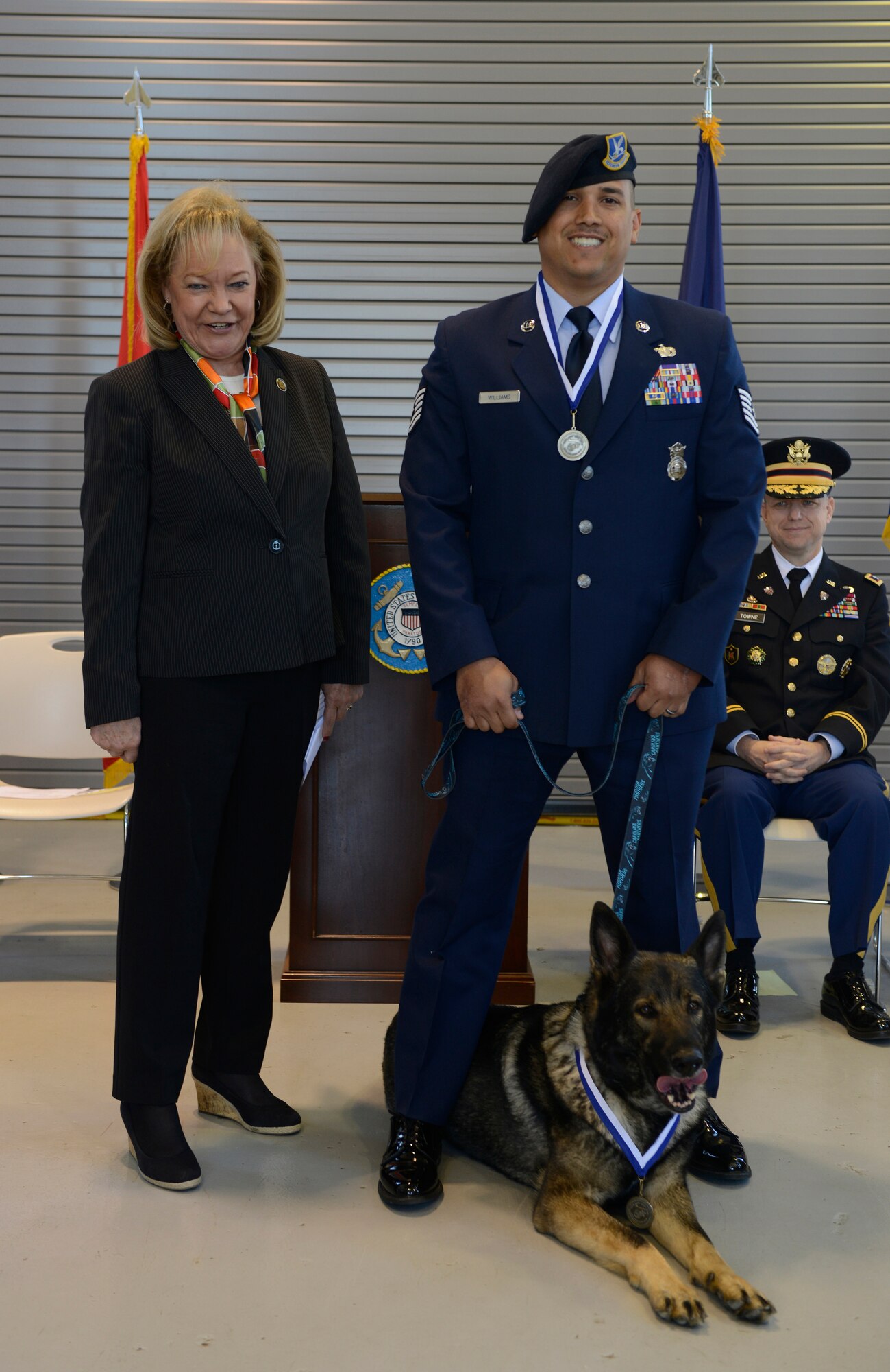 Susan C. Haines, the national executive director of Exercise Tiger, stands with Air Force Tech. Sgt. Brian Williams at Coast Guard Station Barnegat Light, N.J., April 28, 2015. The annual ceremony is held to honor the Soldiers and Sailors who lost their lives during the World War II Battle of Exercise Tiger, April 28, 1944. (U.S. Coast Guard photo by Petty Officer 3rd Class David Micallef/Released)