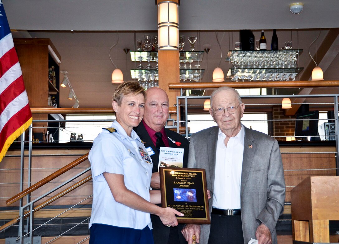 Capt. Amy Concanour and retired Capt. Tom Plantenberg, present the Lance Sijan Award to Ceylon Gruenstern at the Milwaukee Yacht Club May 15, 2015 for his service during World War II. Gruenstern is the great-grandfather of Senior Airman Melissa Mussa, 128th Air Refueling Wing civil engineering squadron.  (U.S. Air National Guard photo by Capt. Matthew Wunderlin/Released)