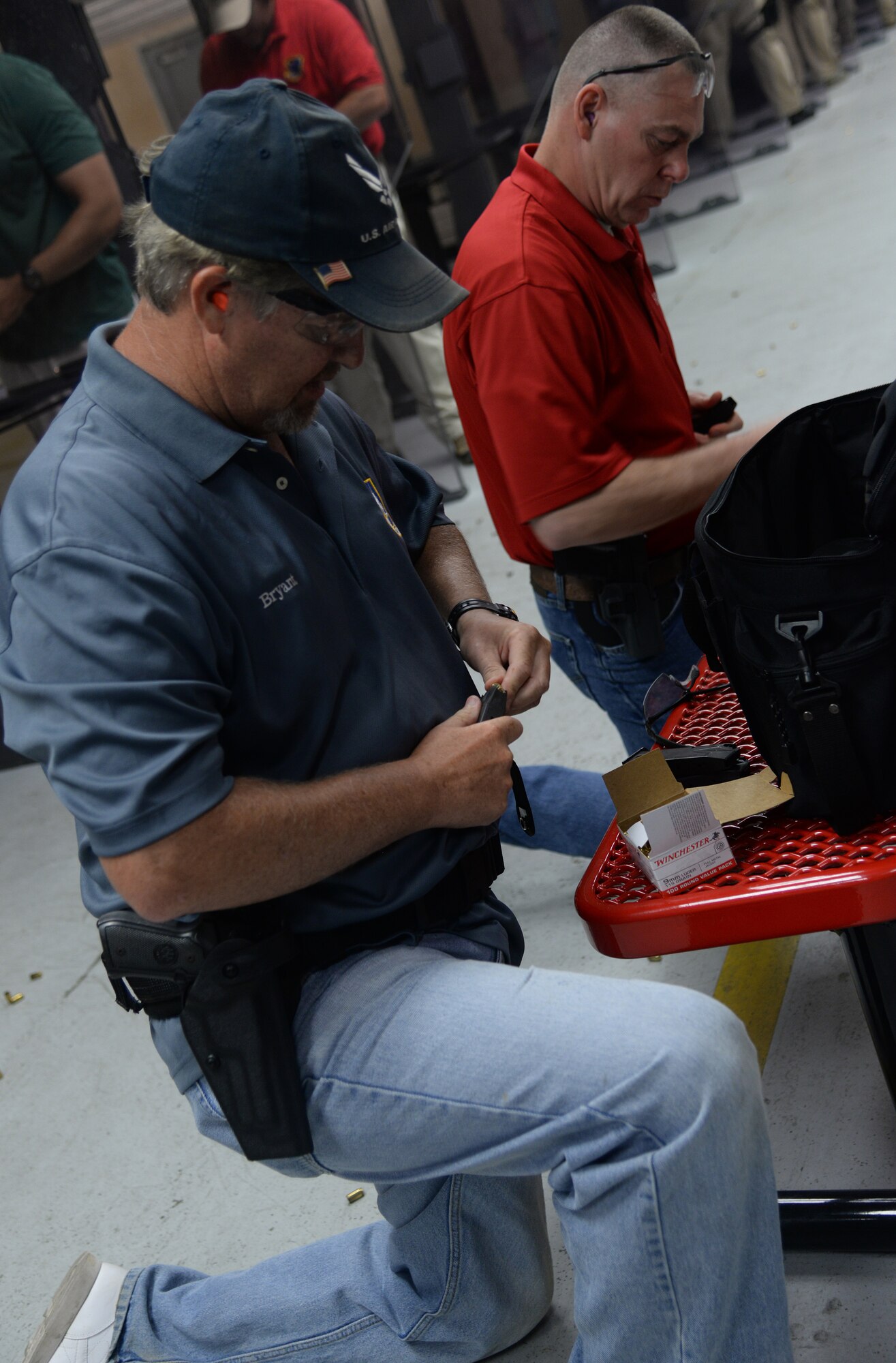 Retired Chief Master Sgt. Jeff Bryant and Maj. Harold Hobgood, 81st Logistics Readiness Squadron team members, load ammo into their magazines during the team shoot competition to celebrate National Police Week, May 14, 2015, Keesler Air Force Base, Miss. The 81st Security Forces Squadron held different events throughout the week to honor fallen security forces and Mississippi state law enforcement while educating the public on law enforcement duties and programs. (U.S. Air Force photo by Senior Airman Holly Mansfield)