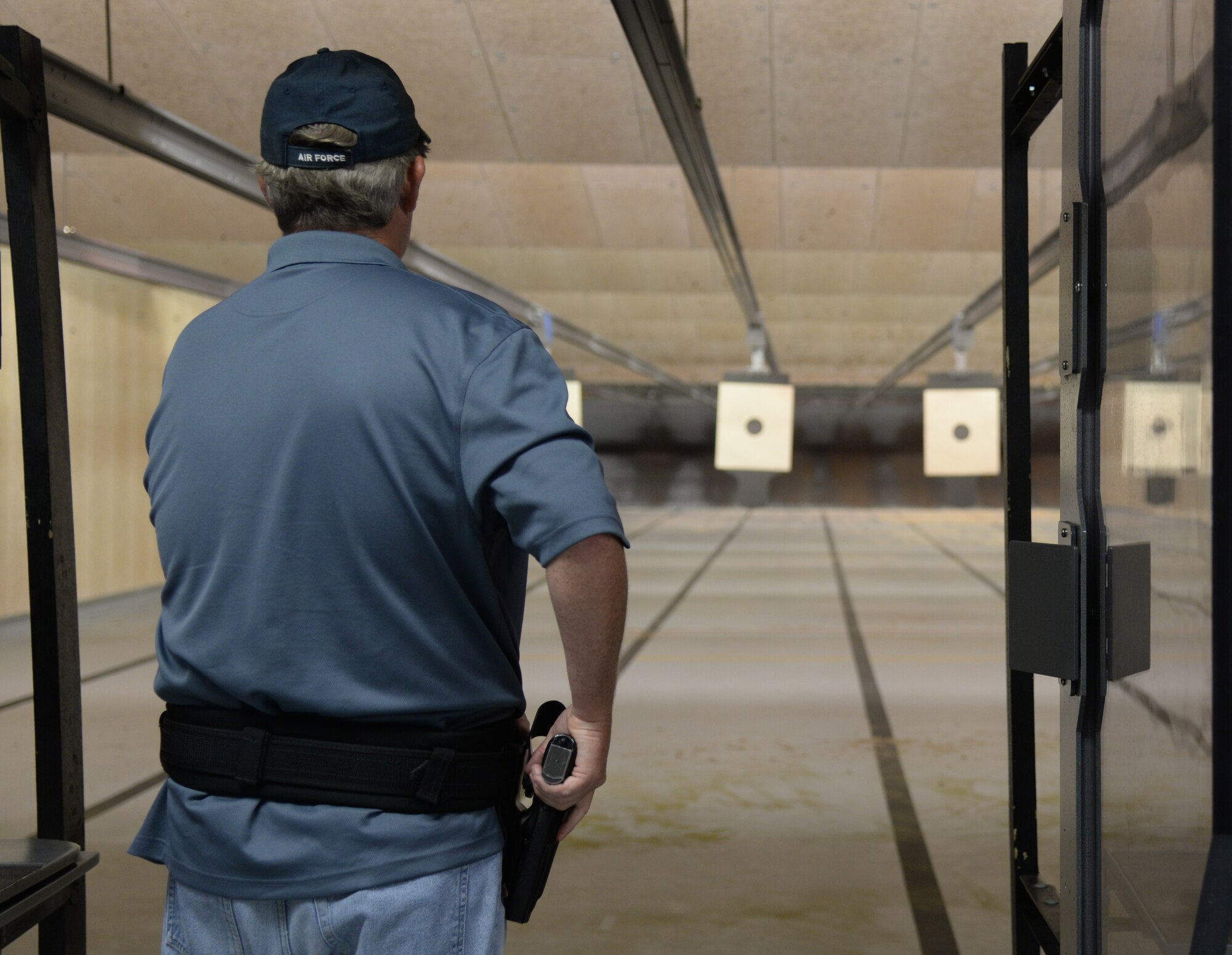 Retired Chief Master Sgt. Jeff Bryant, 81st Logistics Readiness Squadron team member, draws a pistol during the team shoot competition to celebrate National Police Week, May 14, 2015, Keesler Air Force Base, Miss. The 81st Security Forces Squadron held different events throughout the week to honor fallen security forces and Mississippi state law enforcement while educating the public on law enforcement duties and programs. (U.S. Air Force photo by Senior Airman Holly Mansfield)