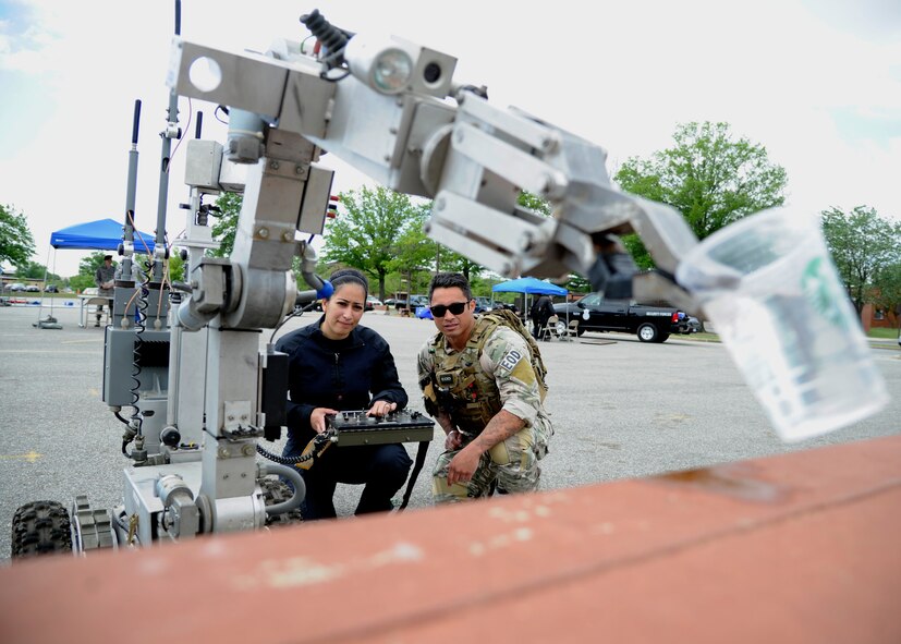 Tech Sgt. Chris Ferrell, 11th Civil Engineer Squadron explosive ordinance disposal craftsman, instructs Airman 1st Class Amanda Mascorro, 11th Security Forces Squadron elite gate guard, how to use Eleanor, an ANDROS F6-A EOD robot, May 13, 2015, as part of a National Police Week demonstration at Joint Base Andrews, Md. During the demonstration, JBA members could get hands-on experience performing tasks security forces and their mission partners are responsible for every day. (U.S. Air Force photo by Senior Airman Preston Webb)