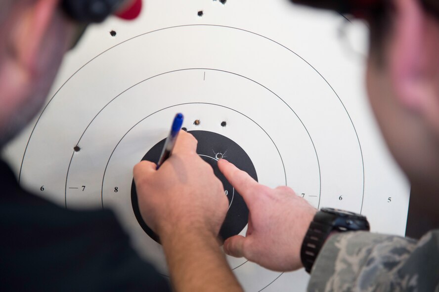 Combat arms instructor and shooter tally bullet holes on the targets during the Excellence in Competition at the firing range on Joint Base Andrews, Md., May 14, 2015. This National Police Week event brought together approximately 130 people and marked the first time this competition was held on JBA.  (U.S. Air Force photo/Airman 1st Class Philip Bryant)