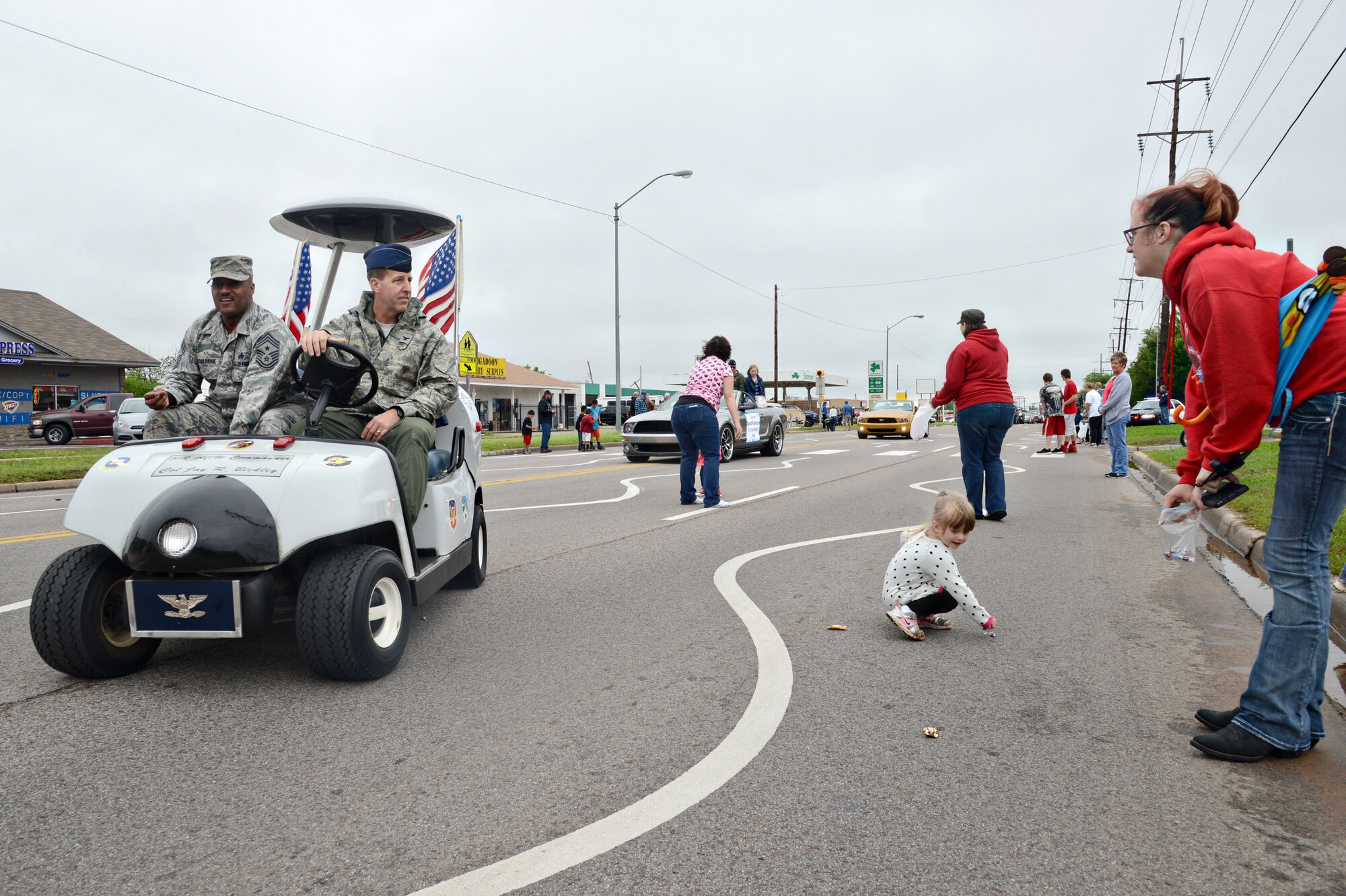 552nd Air Control Wing Commander Col. Jay Bickley, left, and 552md ACW Command Chief Master Sgt. Avery Woolridge toss candy to children and spectators at the May 9 Armed Forces Day Parade in Del City. Despite the threat of flooding and tornadoes earlier in the week, the parade went off without a hitch. Crowds of people lined the streets to watch and numerous floats, military groups and community businesses participated. (Air Force photo by Kelly White/Released)