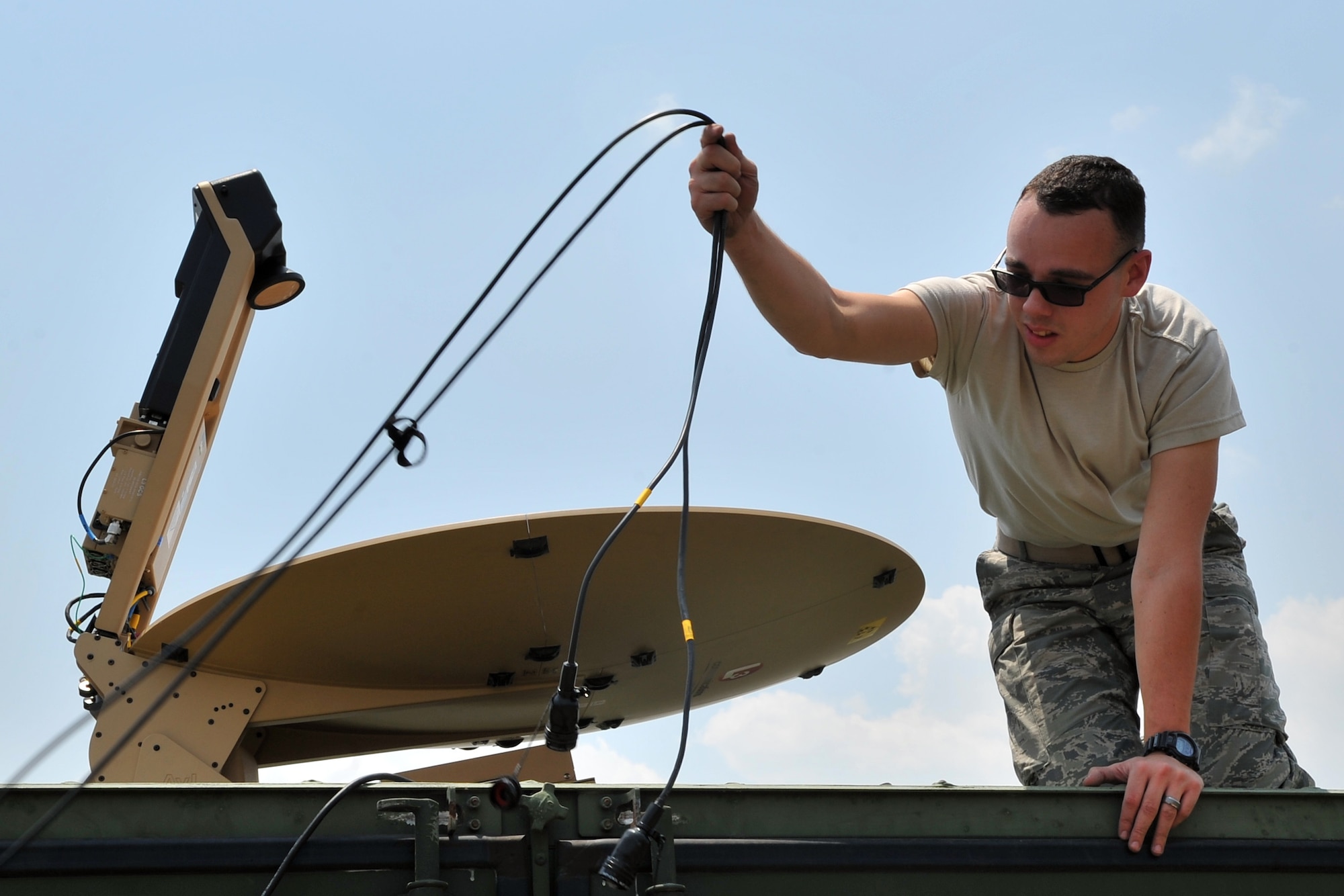 U.S. Air Force Staff Sgt. Matthew Vile, 36th Mobility Response Squadron cyber transport systems technician, sets up a satellite communications antenna at the Tribhuvan International Airport in Kathmandu, Nepal, May 6, 2015. The setup improved airfield radio range communications capabilities for the 36th CRG Airmen who are deployed to Nepal from Andersen Air Force Base, Guam, as part of Joint Task Force-505 participating in Operation Sahayogi Haat. The JTF is in Nepal to help the government and U.S. Agency for International Development with airfield operations and processing relief supplies after an earthquake devastated the country April 25, 2015. (U.S. Air Force photo by Staff Sgt. Melissa B. White/Released)