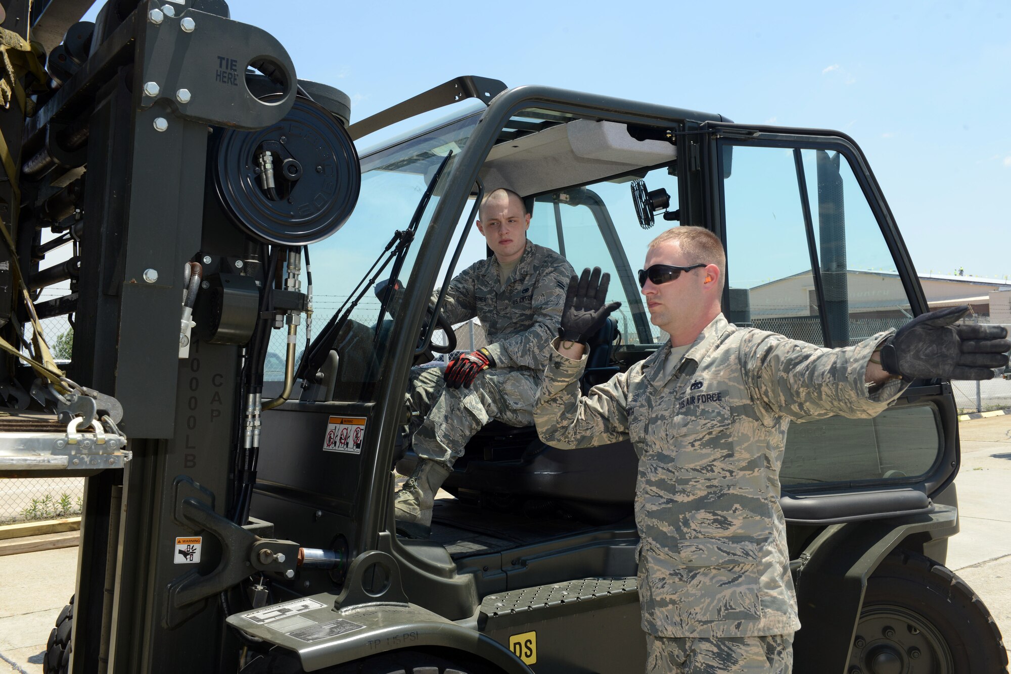Staff Sgt. Clinghton Smith, 78 Logistics Readiness Squadron aircraft transportation specialist,  guides forklift driver Airman 1st Class Braden Goerner as he drives a K-Loader.  (U.S. Air Force photo by Tommie Horton)