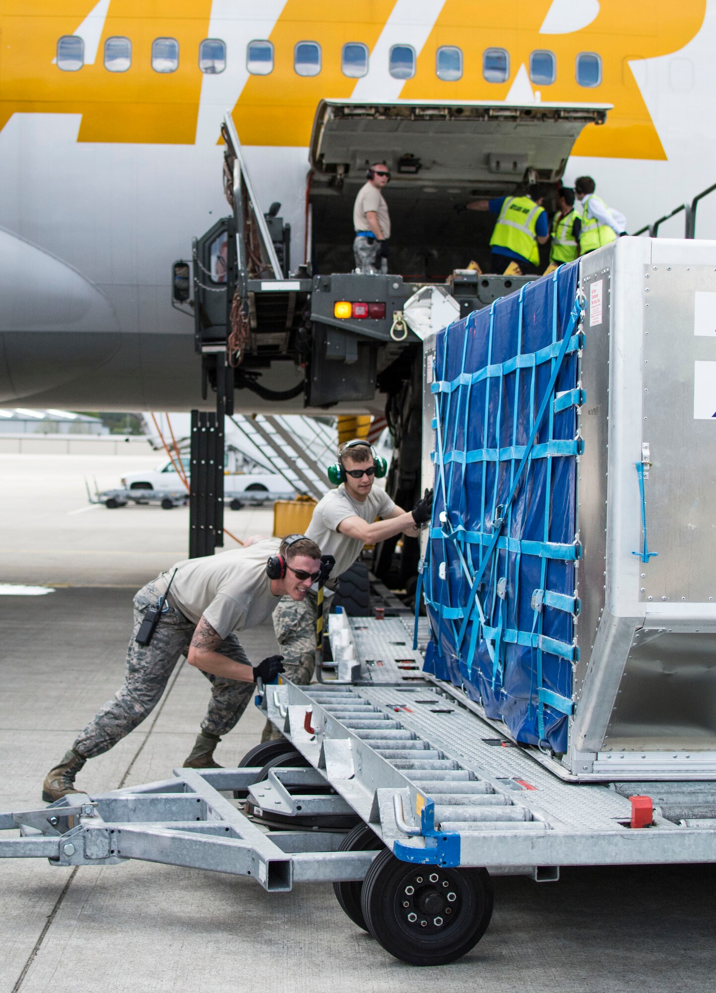 Airman 1st Class Patrick J. Lokhaiser (right), an air transportation specialist with the 32nd Aerial Port Squadron from Pittsburgh, and active-duty counterpart Senior Airman Scott Marvin, an air transportation specialist with the 721st APS here, unload a luggage pod on the flight line Ramstein Air Base, Germany, May 6, 2015. (U.S. Air Force photo by Staff Sgt. Brandy Grace)