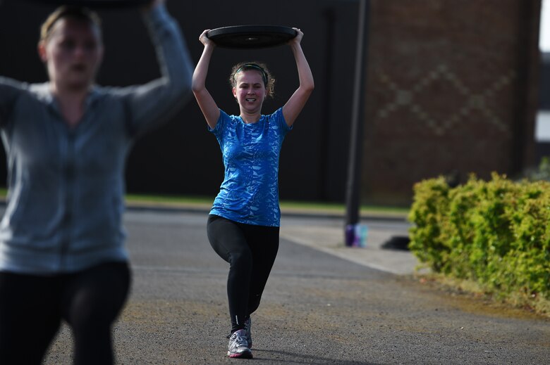 Ashley Sierra, 423rd Force Support Squadron accounting technician, right, performs weighted lunges during the National Police Week Warrior Challenge at RAF Alconbury, England, May 15, 2015. Team from across the base came together at this event to show support for law enforcement officers who had been killed in the line of duty. (U.S. Air Force photo by Staff Sgt. Jarad A. Denton/Released)