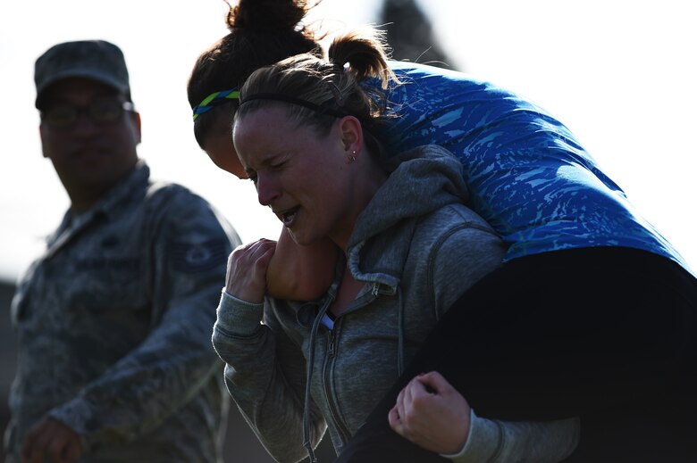 Tracy Huot, 423rd Force Support Squadron accounting technician, hoists her teammate, Ashley Sierra, 423rd FSS accounting technician, during the “fireman’s carry” portion of the National Police Week Warrior Challenge at RAF Alconbury, England, May 15, 2015. During the challenge, each of the seven events were followed by a quarter-mile road run. (U.S. Air Force photo by Staff Sgt. Jarad A. Denton/Released)