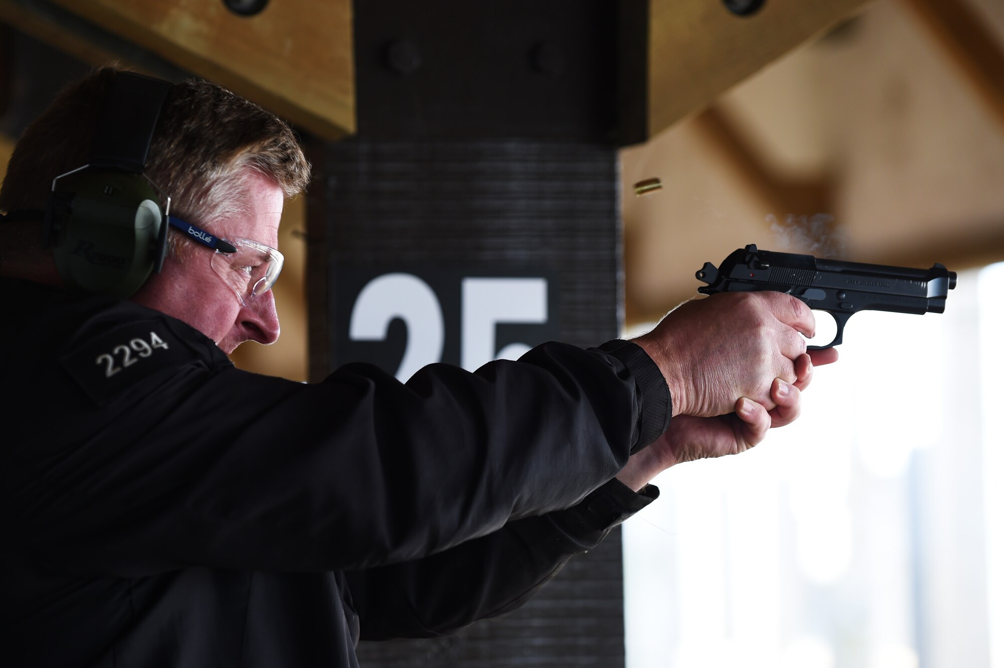 Ministry of Defence Police Constable Garry Phillips, working dog handler, fires an M9 pistol during a during a National Police Week shooting competition at RAF Molesworth, England, May 13, 2015. The competition featured a fitness challenge, followed by range drills with an M4 carbine and M9 pistol. (U.S. Air Force photo by Staff Sgt. Jarad A. Denton/Released) 